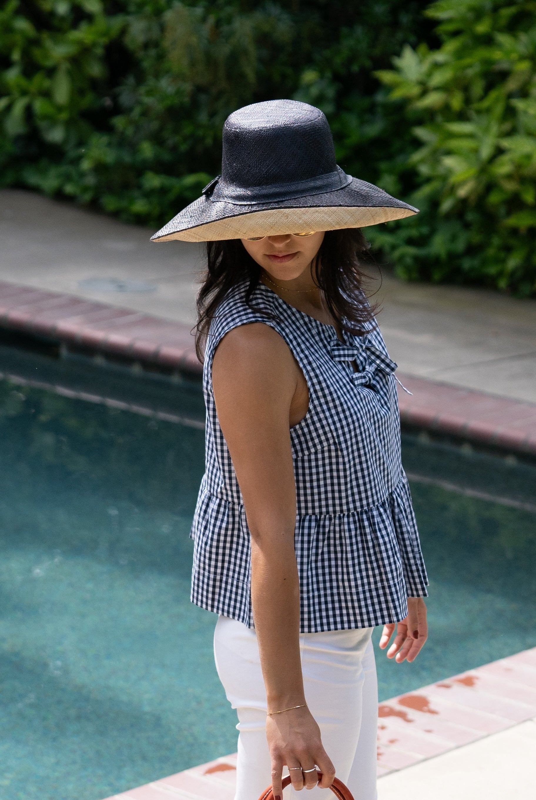 Model wearing Monica 5" & 7" Wide Brim Two Tone Black Packable Straw Sun Hat handmade loomed raffia color block pattern of the top half black and the bottom half natural straw color - Shebobo