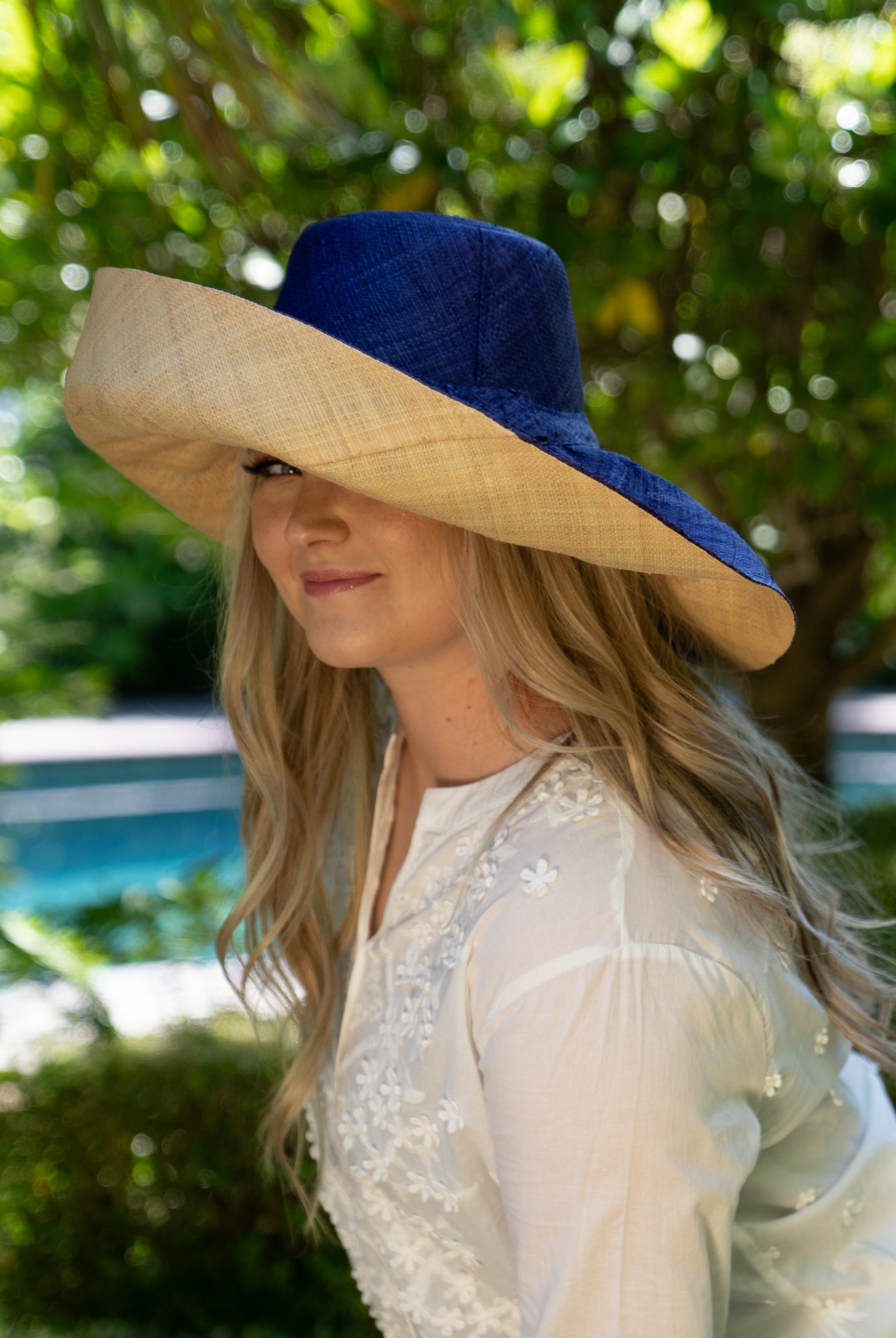 Model wearing Monica 7" wide brim two tone blue top and natural bottom handmade loomed raffia lightweight and packable straw sun hat - Shebobo