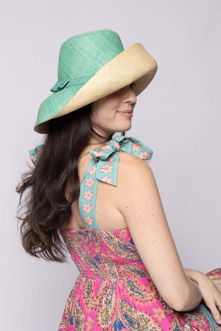 Model wearing Monica 5" & 7" Wide Brim Two Tone Seafoam Packable Straw Sun Hat handmade loomed raffia in a color block of the top half of the hat in seafoam light/blue/green and the bottom half natural straw color - Shebobo