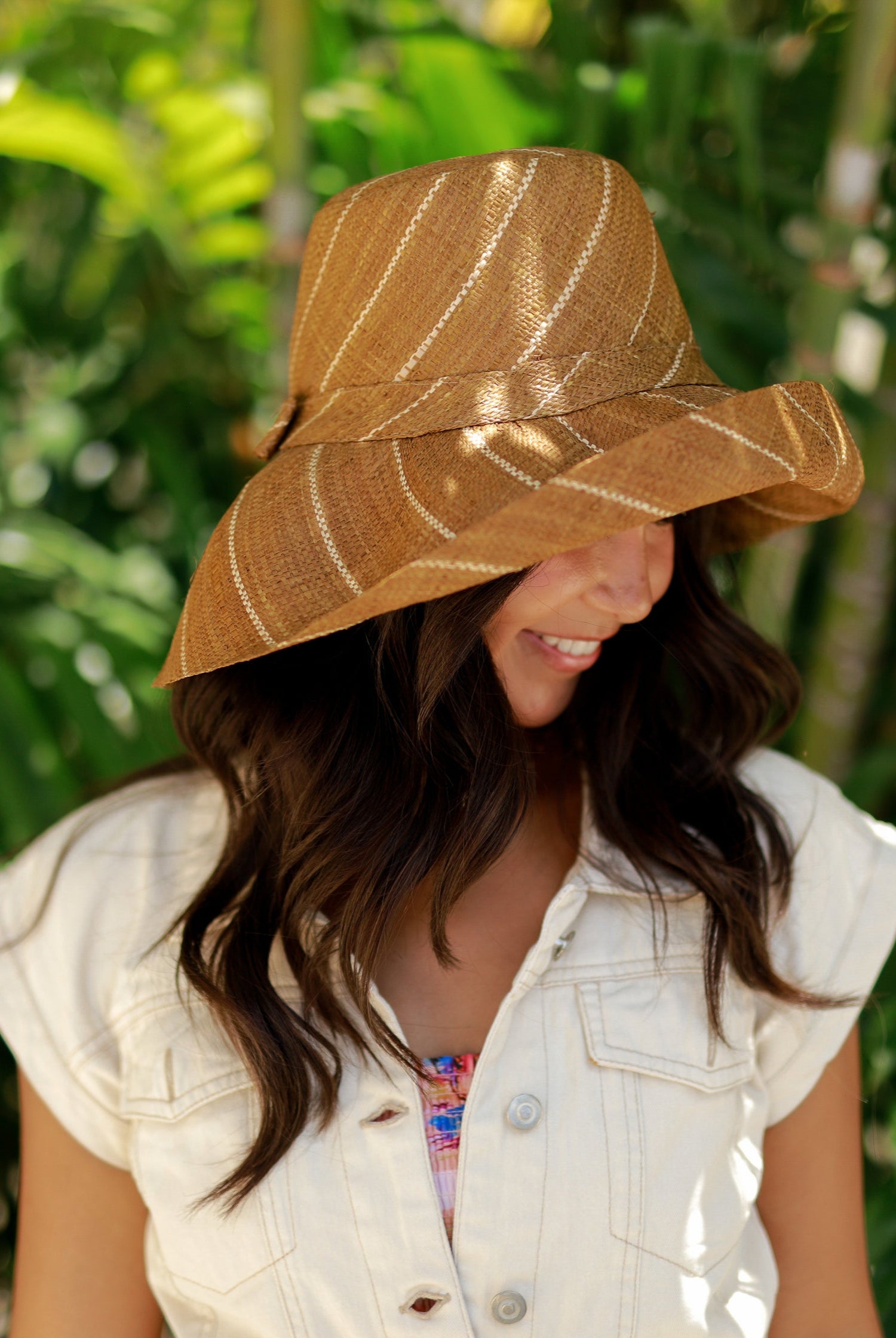 Model wearing Monica 5" Wide Brim Cinnamon Pinstripes Packable Straw Sun Hat handmade loomed raffia in wide bands of cinnamon/tobacco/brown with narrow bands of natural straw color create a striped swirl pattern - Shebobo