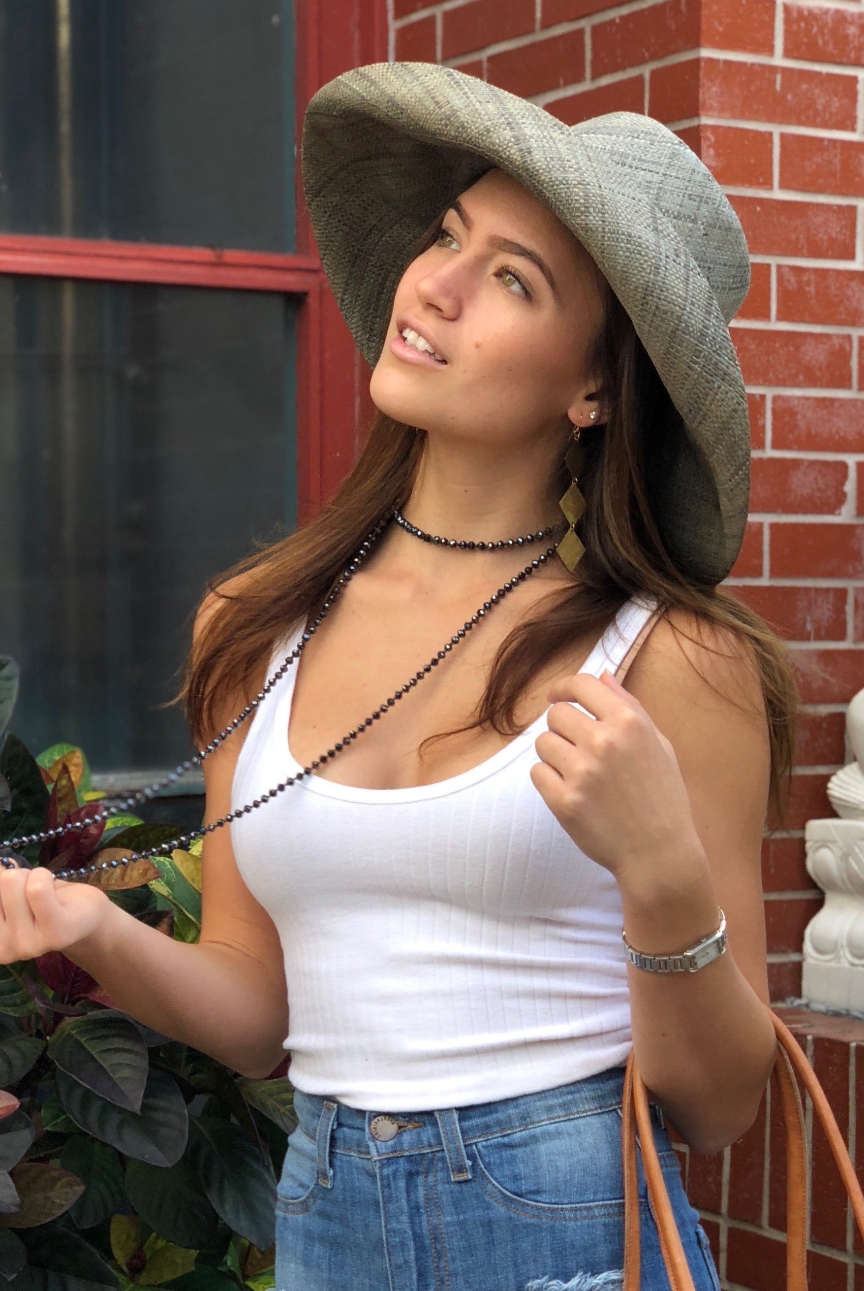 Model wearing Monica 5" Wide Brim Solid Color Packable Straw Sun Hat handmade loomed raffia in a solid hue of pewter light/grey - Shebobo