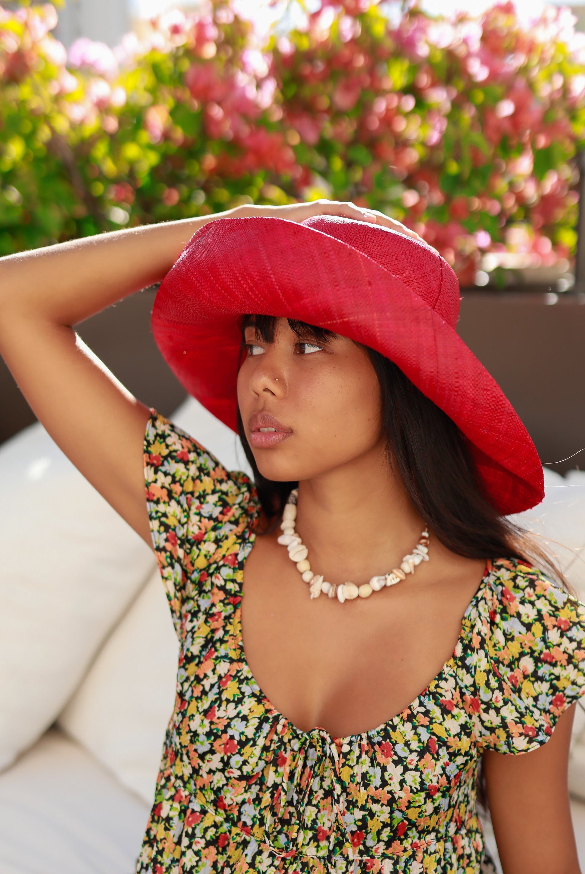 Model wearing Monica 5" Wide Brim Red Packable Straw Sun Hat handmade loomed raffia in a solid hue of red lightweight malleable flexible sun protection hat - Shebobo