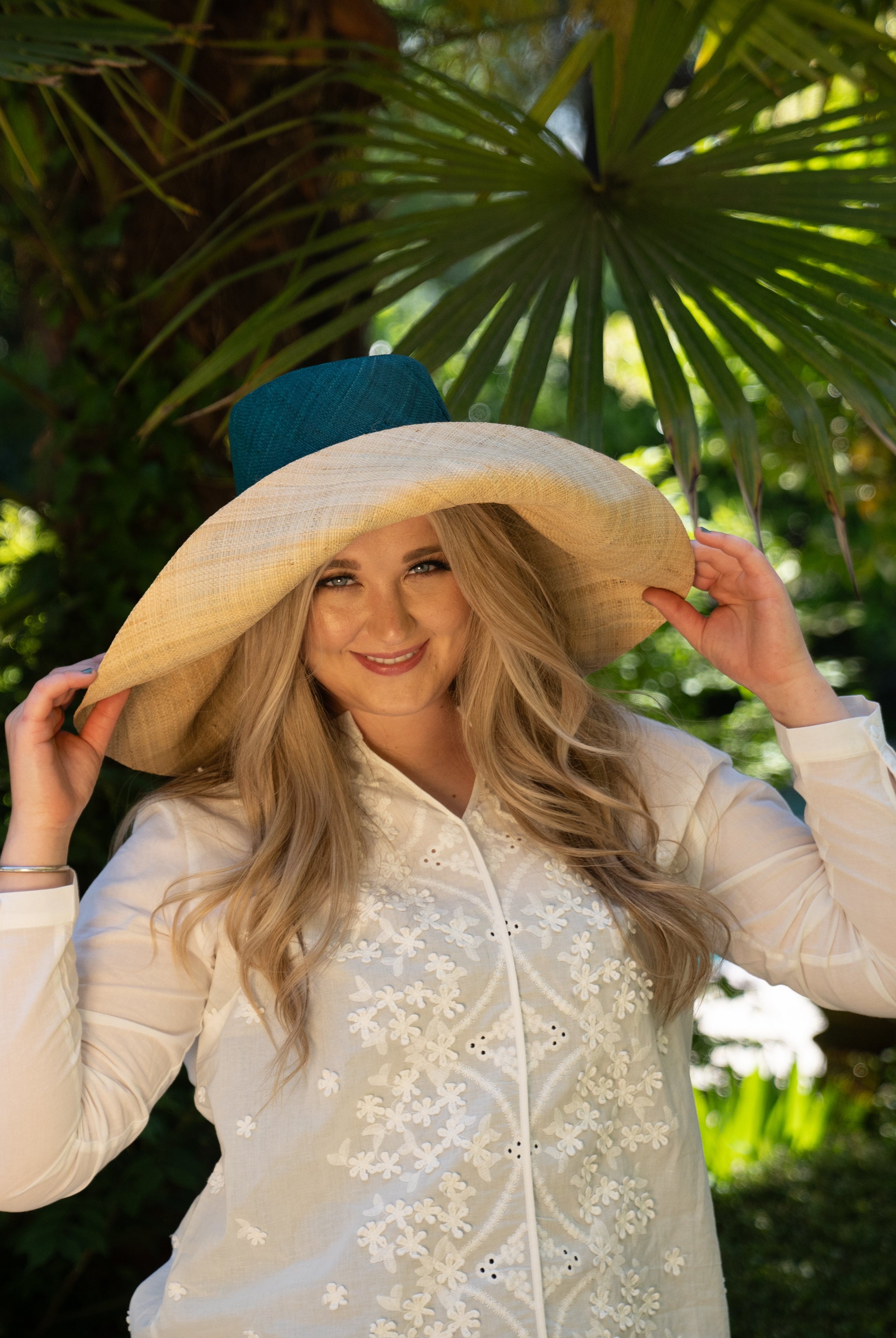 Model wearing Monica 7" wide brim handmade teal dark/blue/green top half and natural straw color bottom half two tone loomed raffia sun protection packable lightweight straw hat - Shebobo