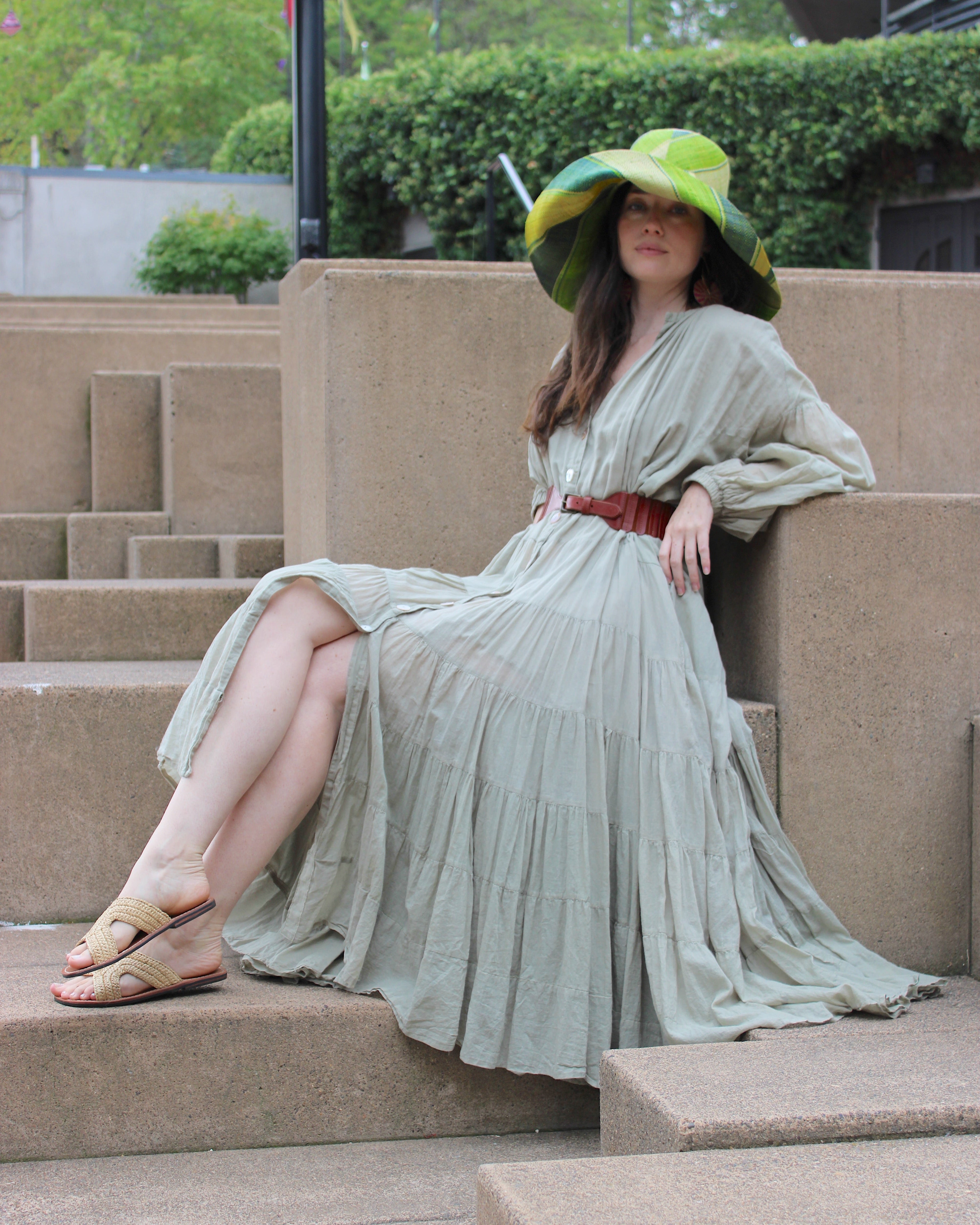 Model wearing Monica 7" Wide Brim Izarra Swirl Multicolor Stripes Packable Straw Sun Hat Handmade loomed raffia in multi width bands of midori lime/green, teal, dusk navy/dark/blue, yellow, natural straw color etc. create a swirl pattern - Shebobo