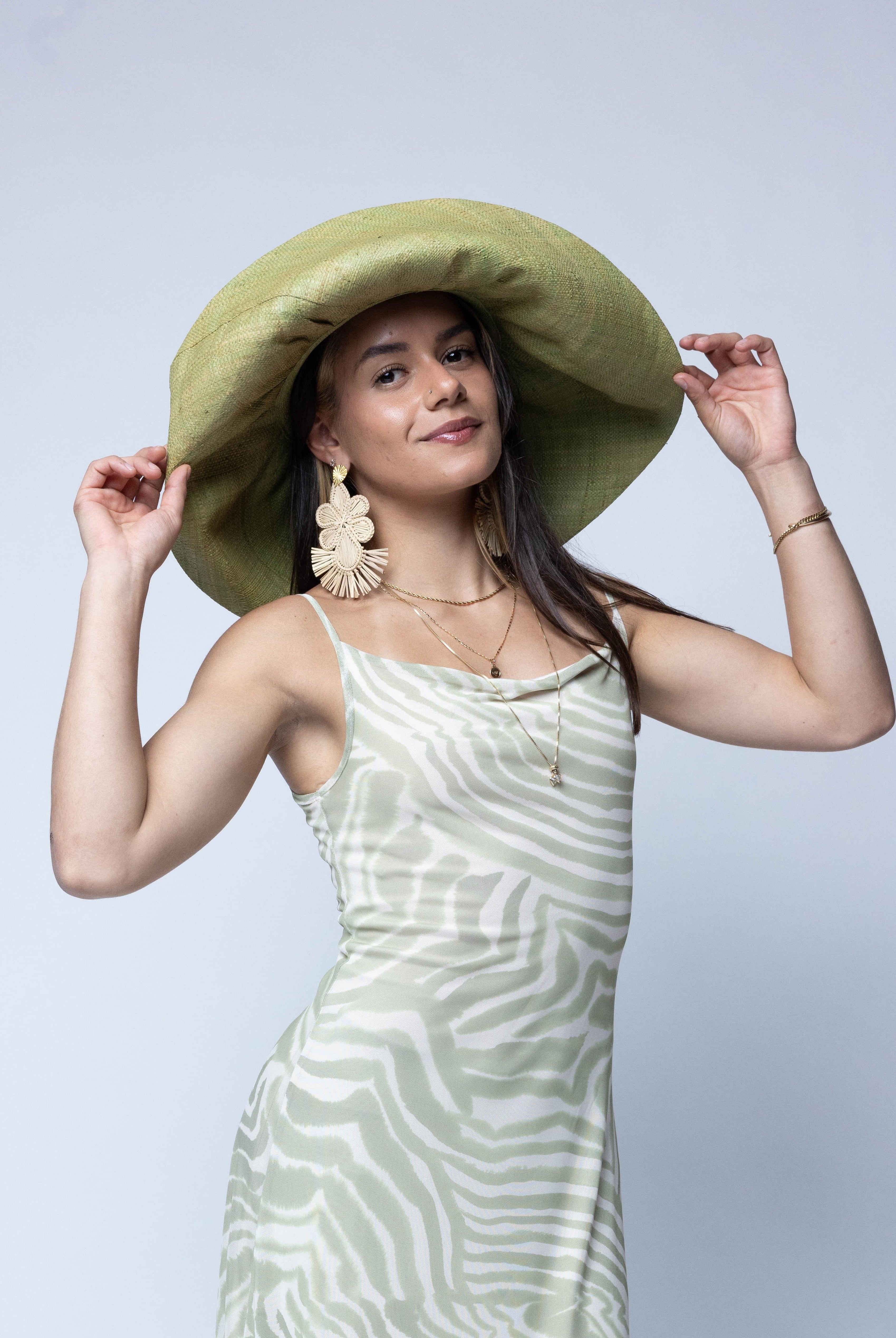 Model wearing Monica 7" Wide Brim Solid Color Packable Straw Sun Hat handmade loomed raffia in a solid hue of Matcha light/meadow/yellow/green - Shebobo