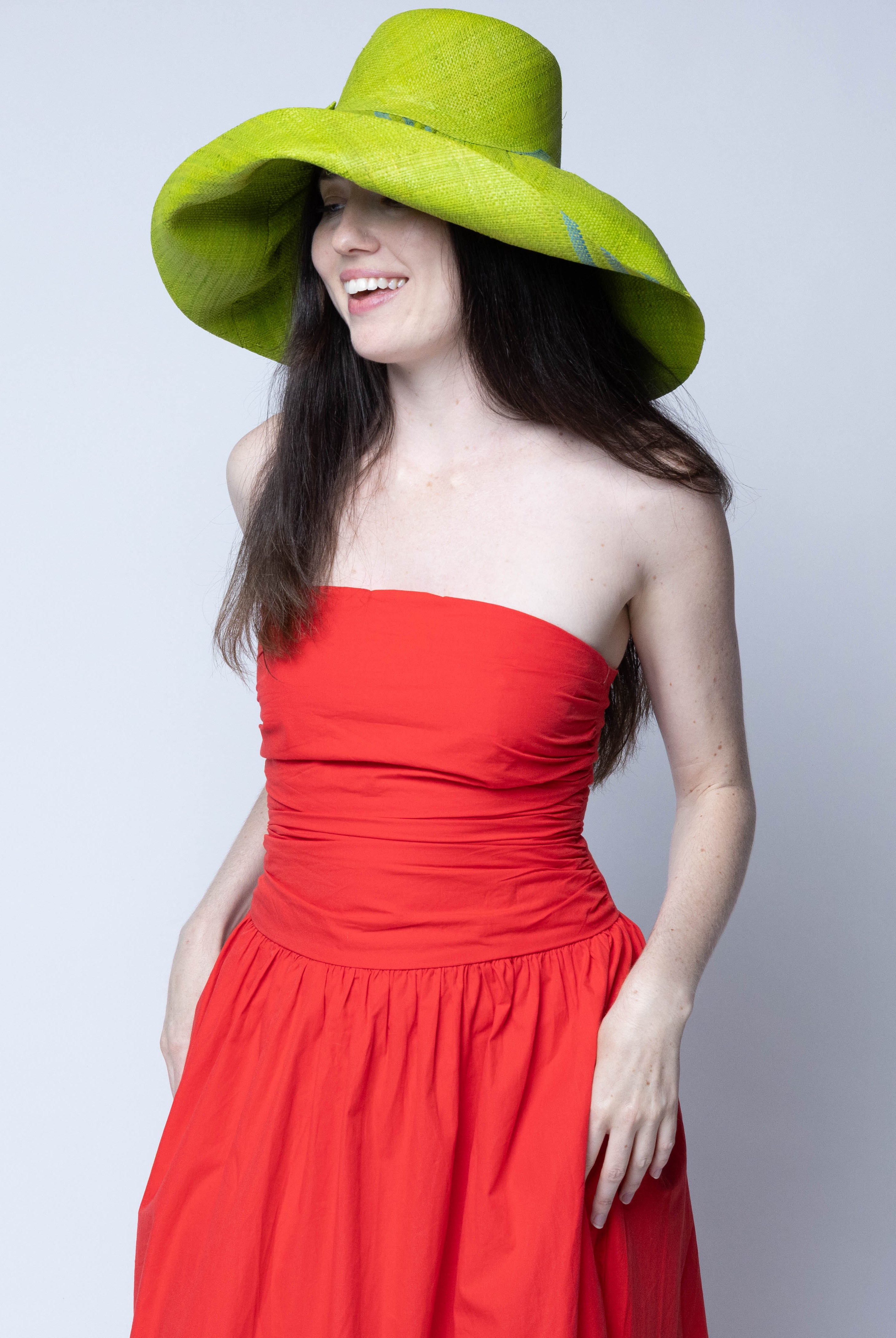 Model wearing Monica 5" & 7" Wide Brim Racing Stripe Packable Straw Sun Hats handmade loomed natural raffia palm fiber in a solid hue of midori bright/neon/lime/green with a three stripe racing stripe pinstripe pattern of turquoise blue/green that creates a swirl around the crown and brim of the hat lightweight breathable sun protection - Shebobo