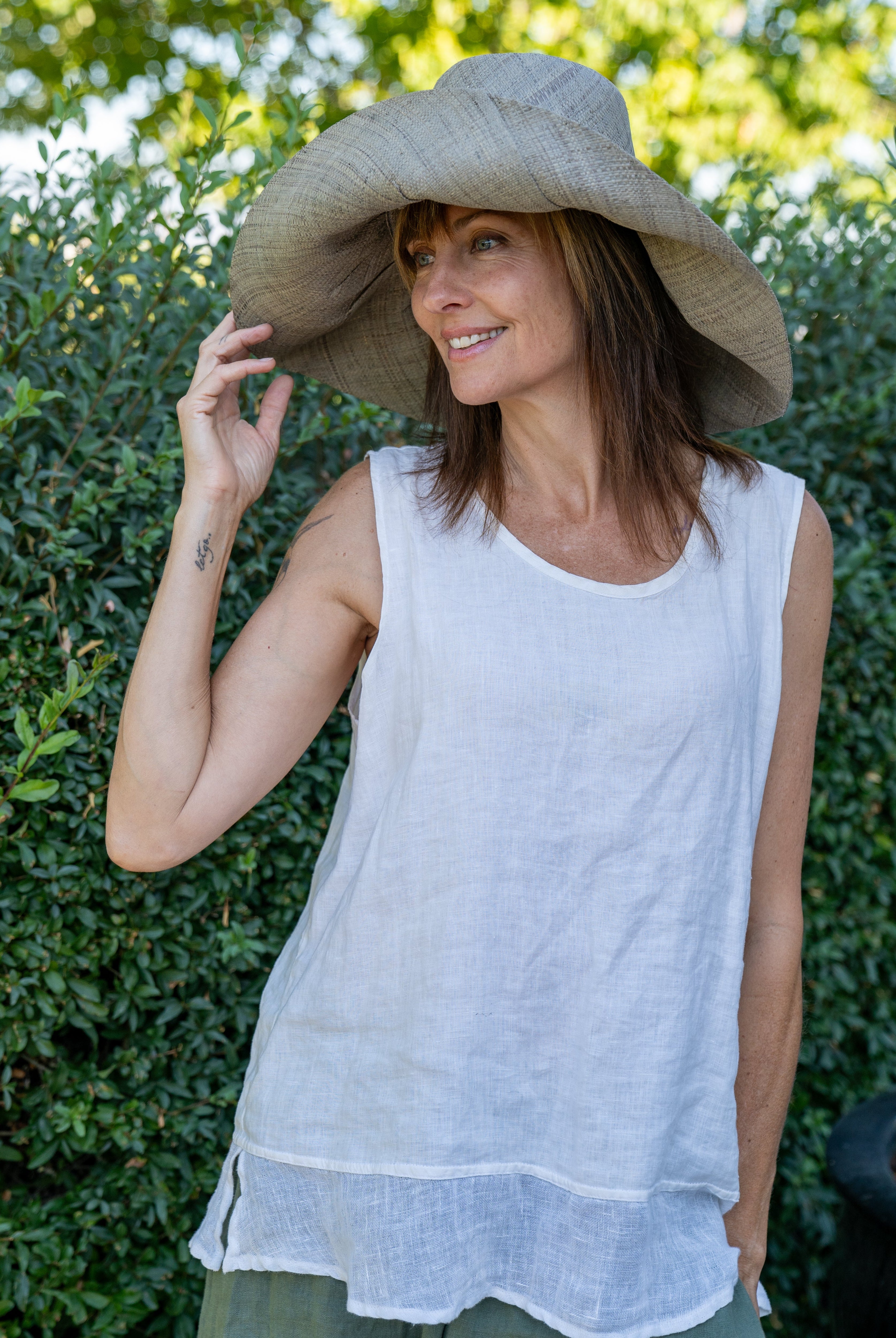 Model wearing Monica 7" Wide Brim Pewter Packable Straw Sun Hat handmade loomed raffia in a solid hue of light grey lightweight malleable flexible sun protection hat - Shebobo