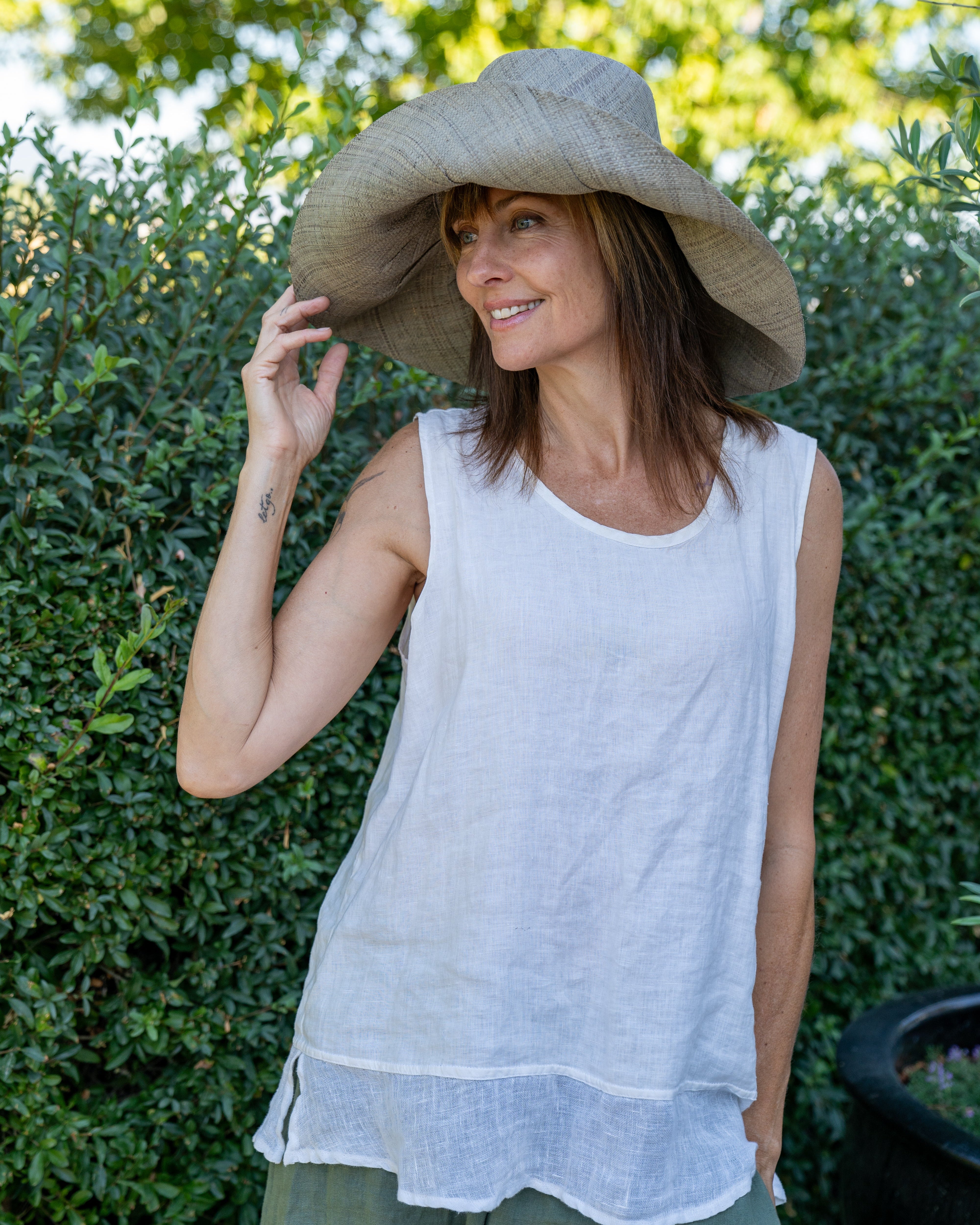 Model wearing Monica 7" Wide Brim Pewter Packable Straw Sun Hat handmade loomed raffia in a solid hue of light grey lightweight malleable flexible sun protection hat - Shebobo