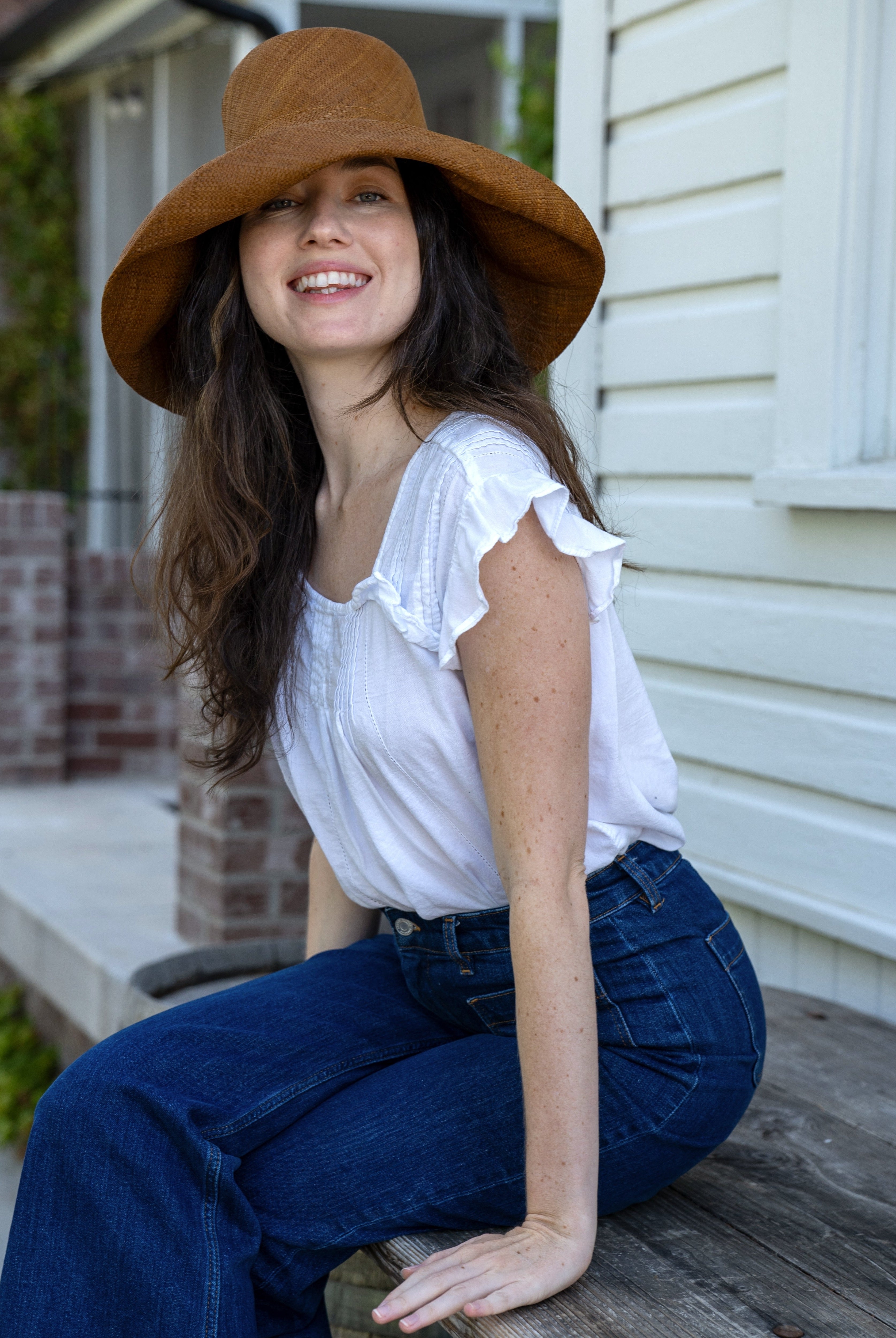 Model wearing 5" & 7" Wide Brim Cinnamon Packable Straw Sun Hat handmade loomed natural raffia palm fiber in a solid hue of cinnamon/tobacco/dark/brown - Shebobo