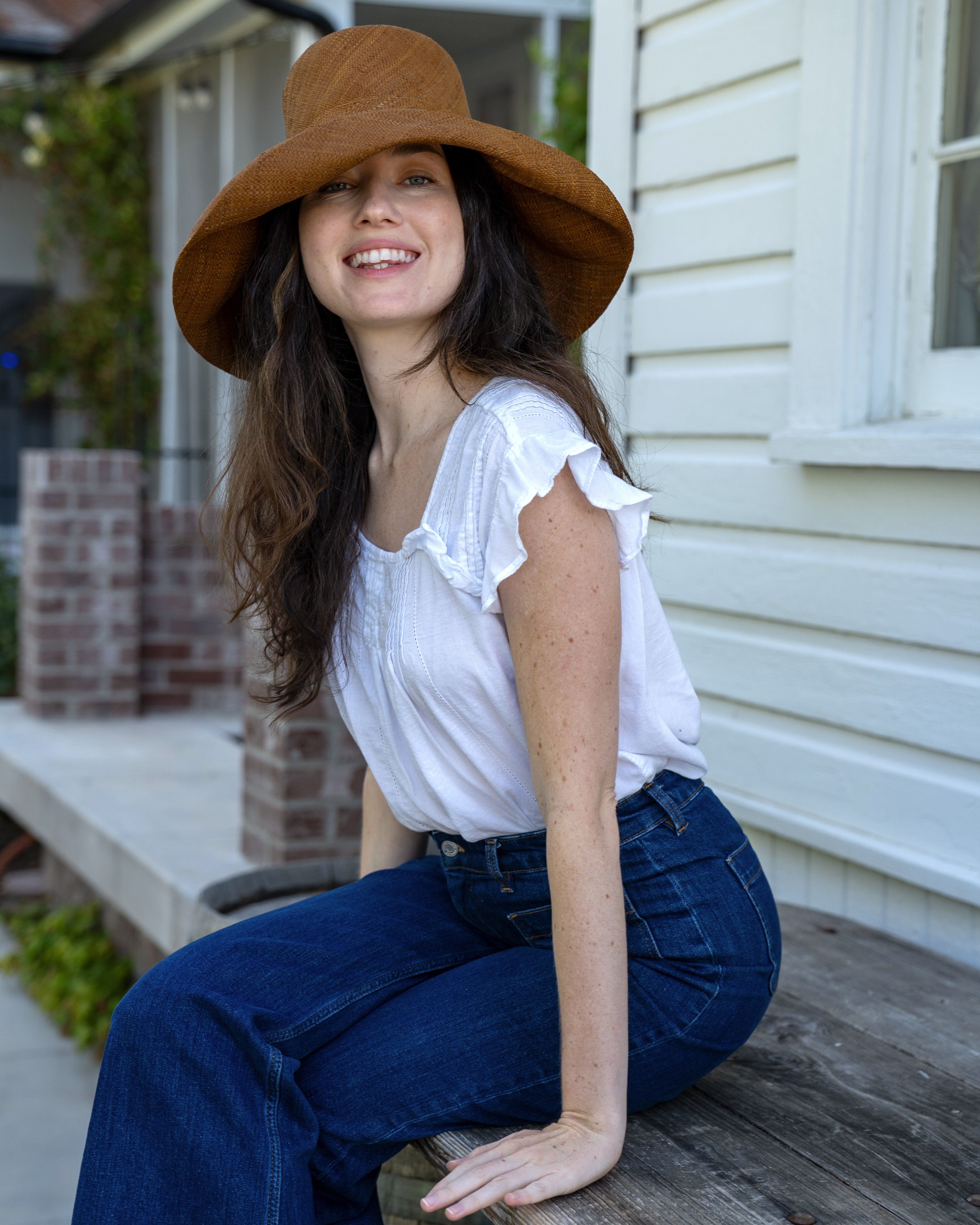 Model wearing 5" & 7" Wide Brim Cinnamon Packable Straw Sun Hat handmade loomed natural raffia palm fiber in a solid hue of cinnamon/tobacco/dark/brown - Shebobo
