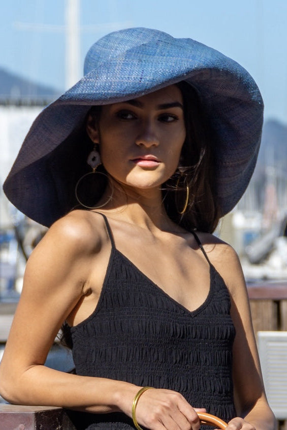Model wearing Monica 7" Wide Brim Turquoise Packable Straw Sun Hat handmade loomed raffia in a solid hue of turquoise blue lightweight malleable flexible sun protection hat - Shebobo