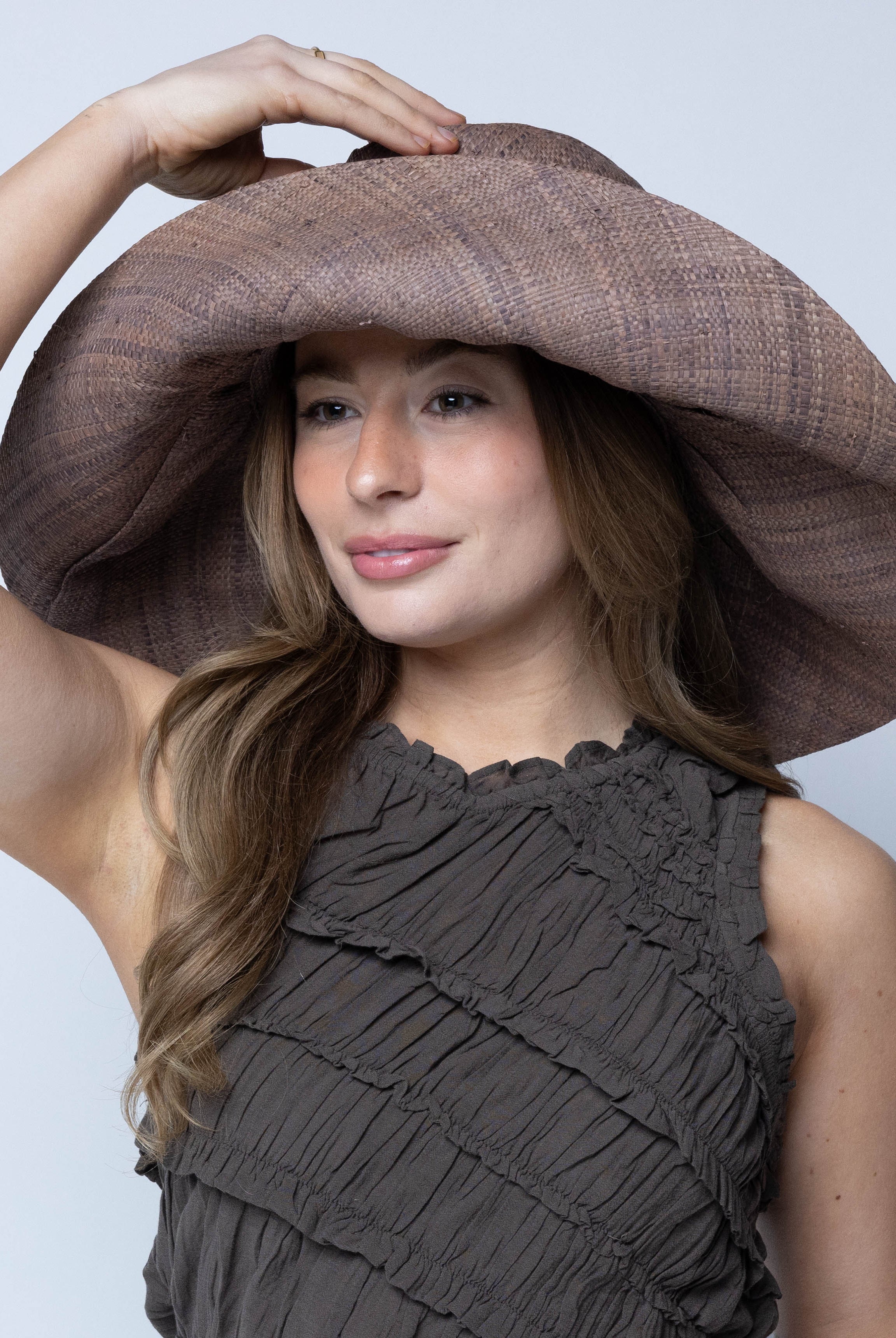 Model wearing Monica 7" Wide Brim Violet Smoke Packable Straw Sun Hat handmade loomed raffia in a solid hue of purple/grey lightweight malleable flexible sun protection hat - Shebobo