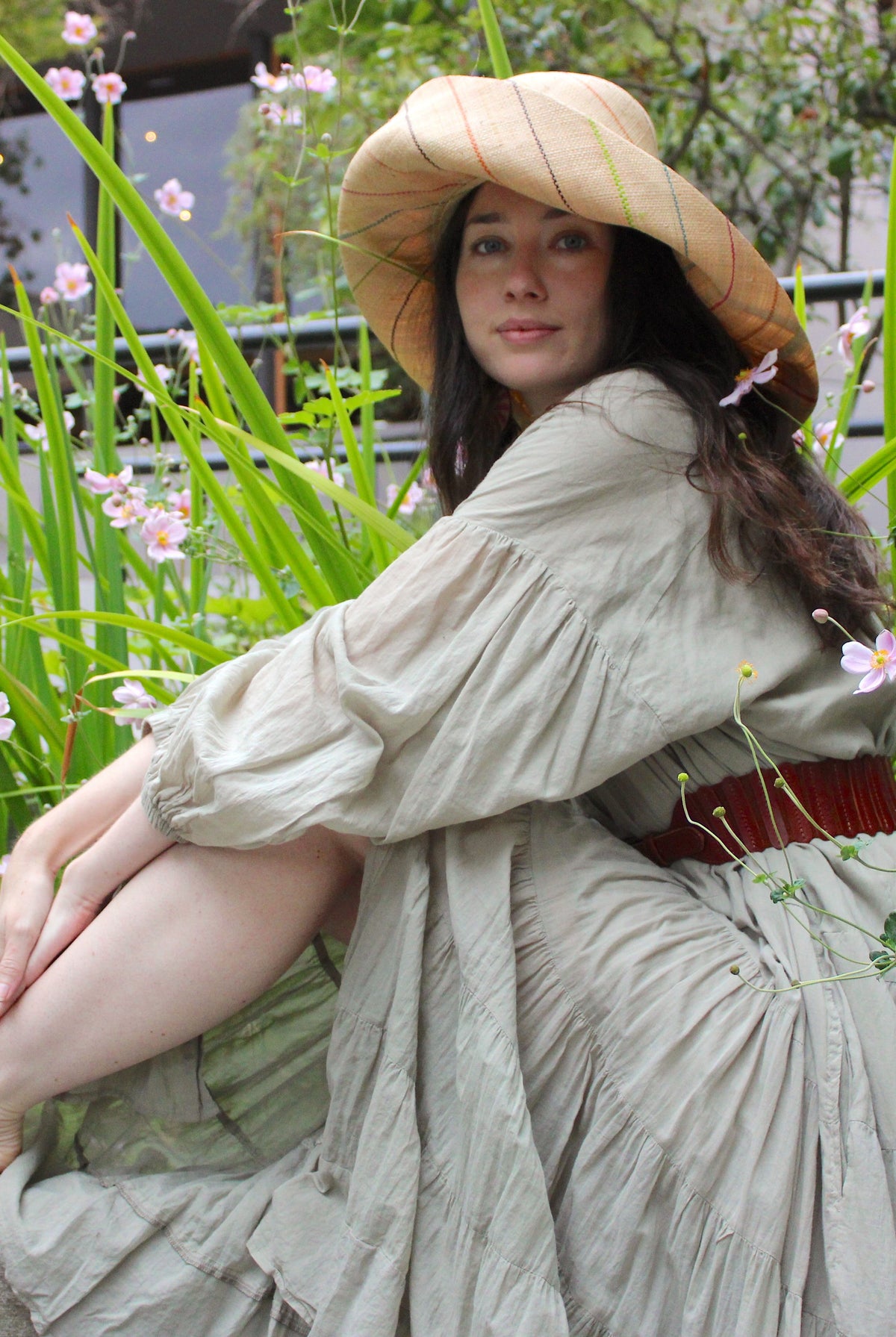 Model wearing Monica 5" or 7" wide brim natural and brights multicolor pinstripes packable raffia straw hat handmade loomed raffia in wide bands of natural straw color with narrow bands of lime green, bordeaux red, fuchsia pink, orange, cinnaon/tobacco/brown, blush orange/pink, etc. create a stripe swirl pattern - Shebobo