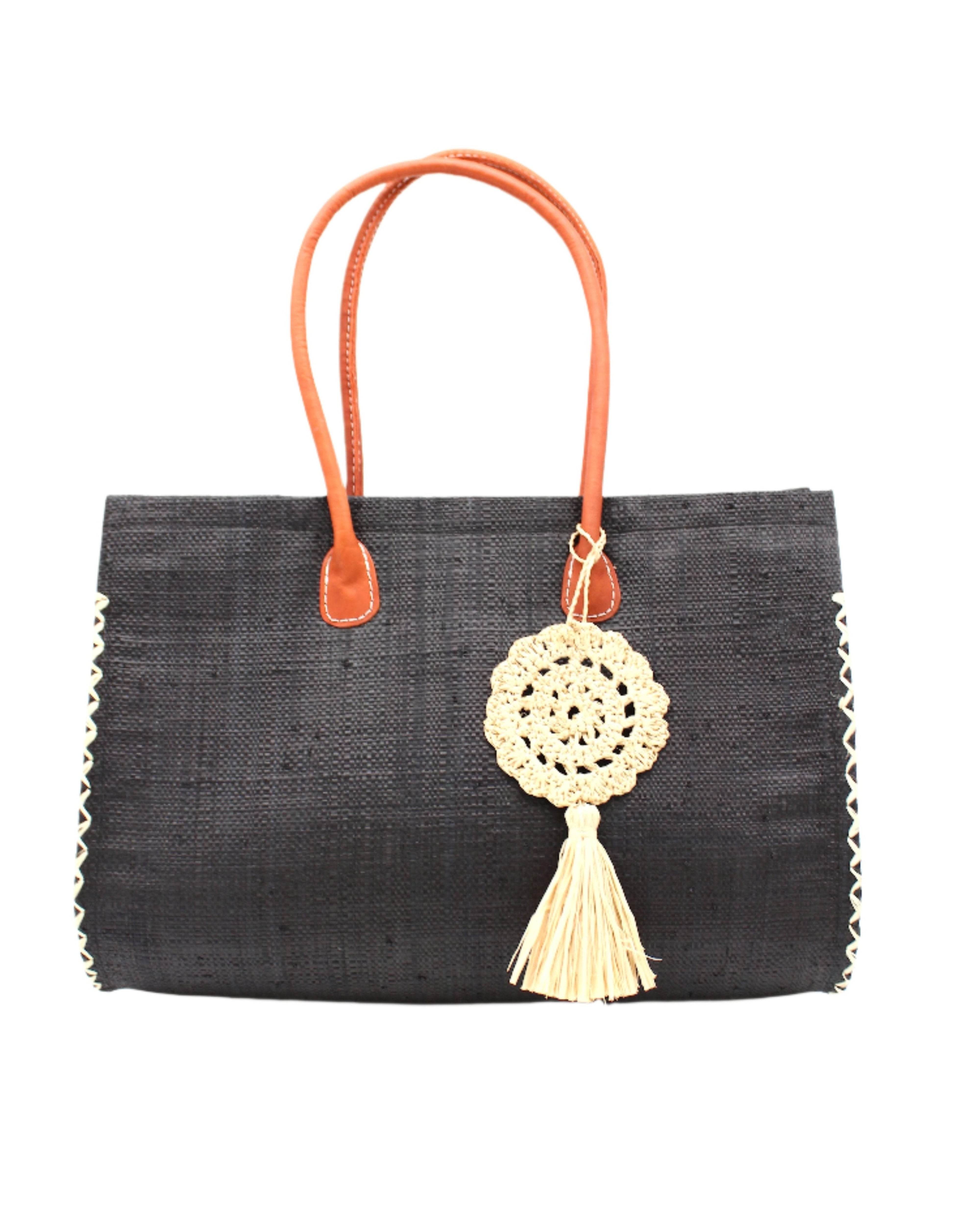 Monte Carlo Big Straw Beach Bag with Dreamcatcher Tassel Charm Embellishment handmade loomed raffia palm fiber in a solid hue of black with contrasting crosshatch stitch edging in natural straw color with matching crochet dreamcatcher disc and tuft tassel charm embellishment and leather handles oversized large handbag shoulder bag - Shebobo