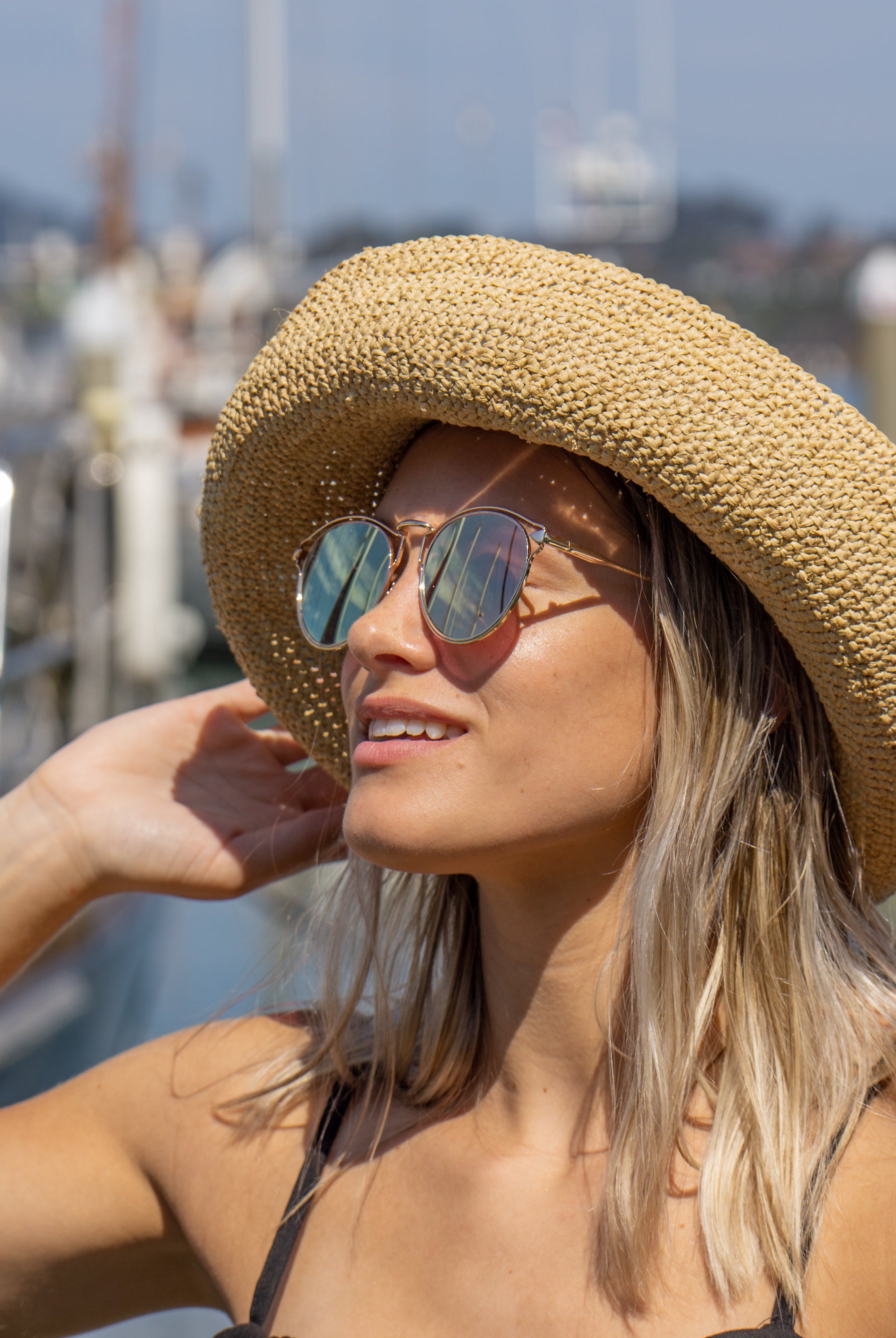 Model wearing Leor Natural crochet straw hat handmade natural straw color raffia 3" brim packable straw hat with matching adjustable braided hat band - Shebobo