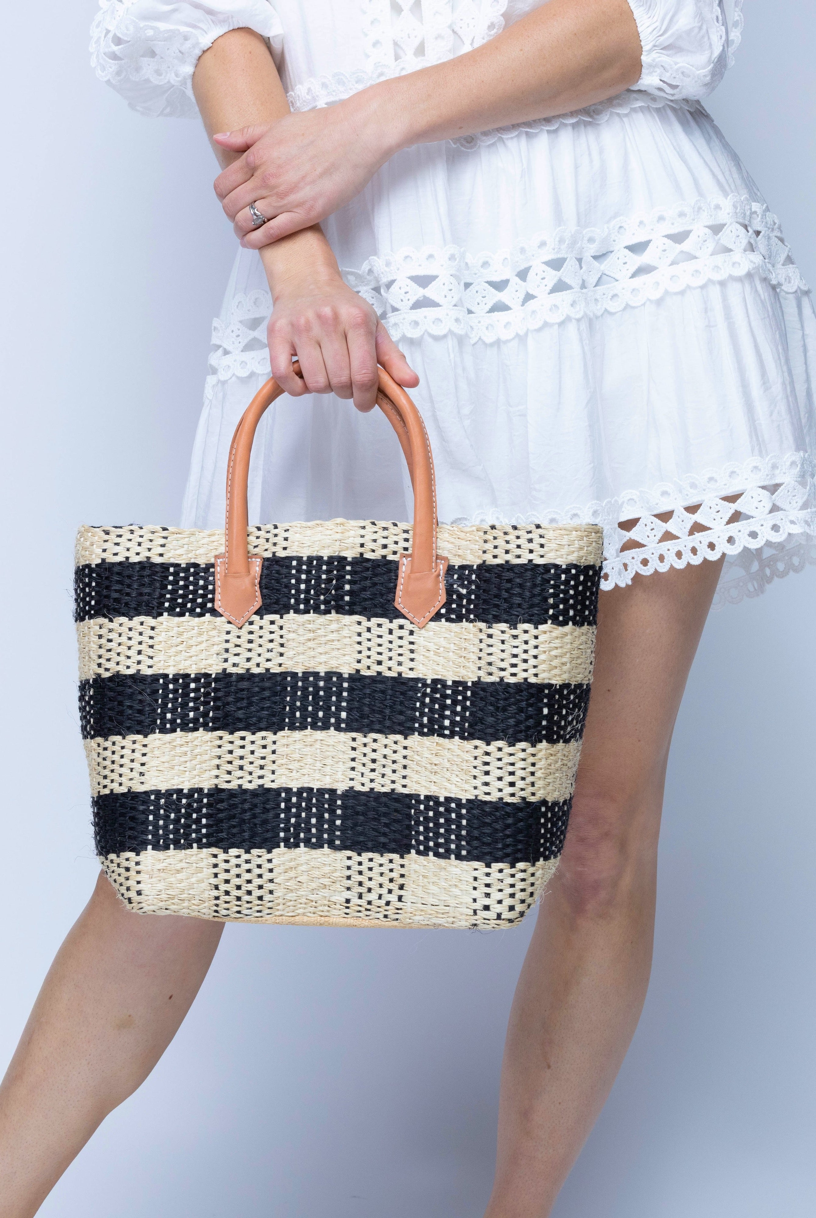 Model wearing Newport Black Gingham Sisal Basket Bag handmade woven natural sisal fibers in a two tone color plaid pattern of black and natural straw color handbag with leather handles purse beach bag - Shebobo