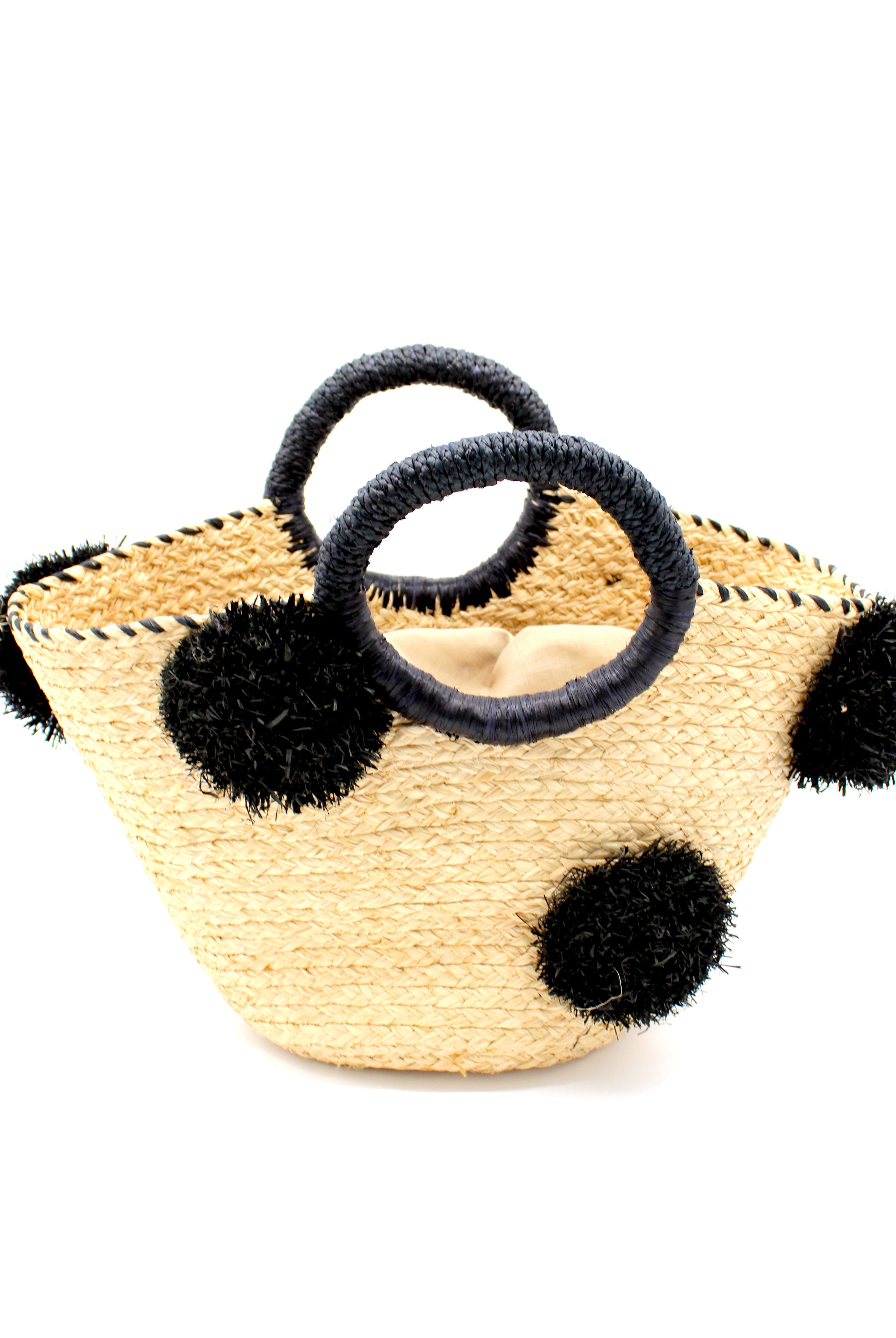 Phi Phi Black and Natural Braided Straw Basket with Oversized Raffia Poufs handmade raffia palm fiber braided into a solid hue of natural straw color with three randomly placed black hand-brushed fringe poufs per side for embellishment with matching loop wrap top edging and matching crochet loop/braided handles bag handbag - Shebobo