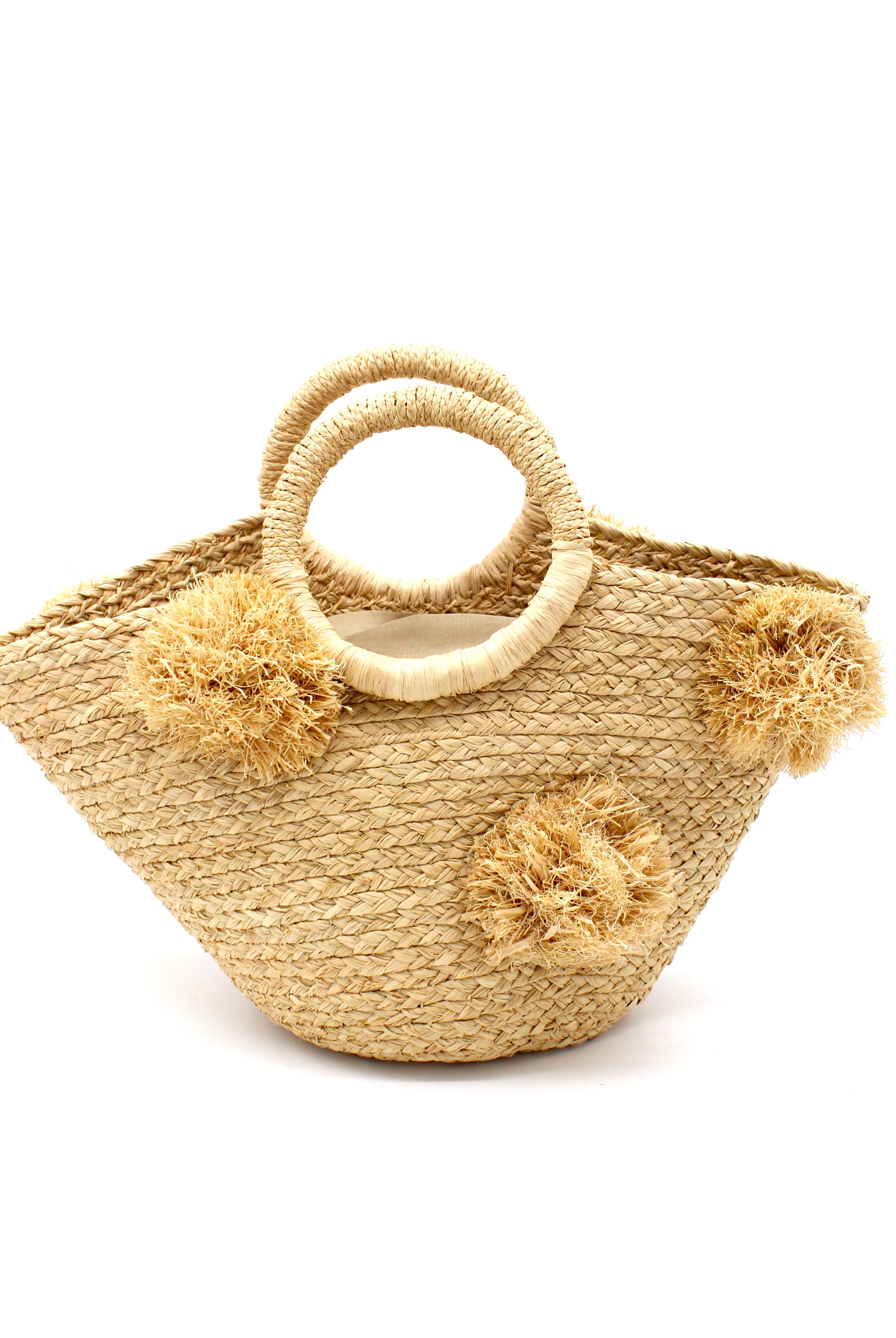 Phi Phi Natural Braided Straw Basket with Oversized Raffia Poufs handmade raffia palm fiber braided into a solid hue of natural straw color with three randomly placed matching hand-brushed fringe poufs per side for embellishment with loop wrap top edging and crochet loop/braided handles bag handbag - Shebobo
