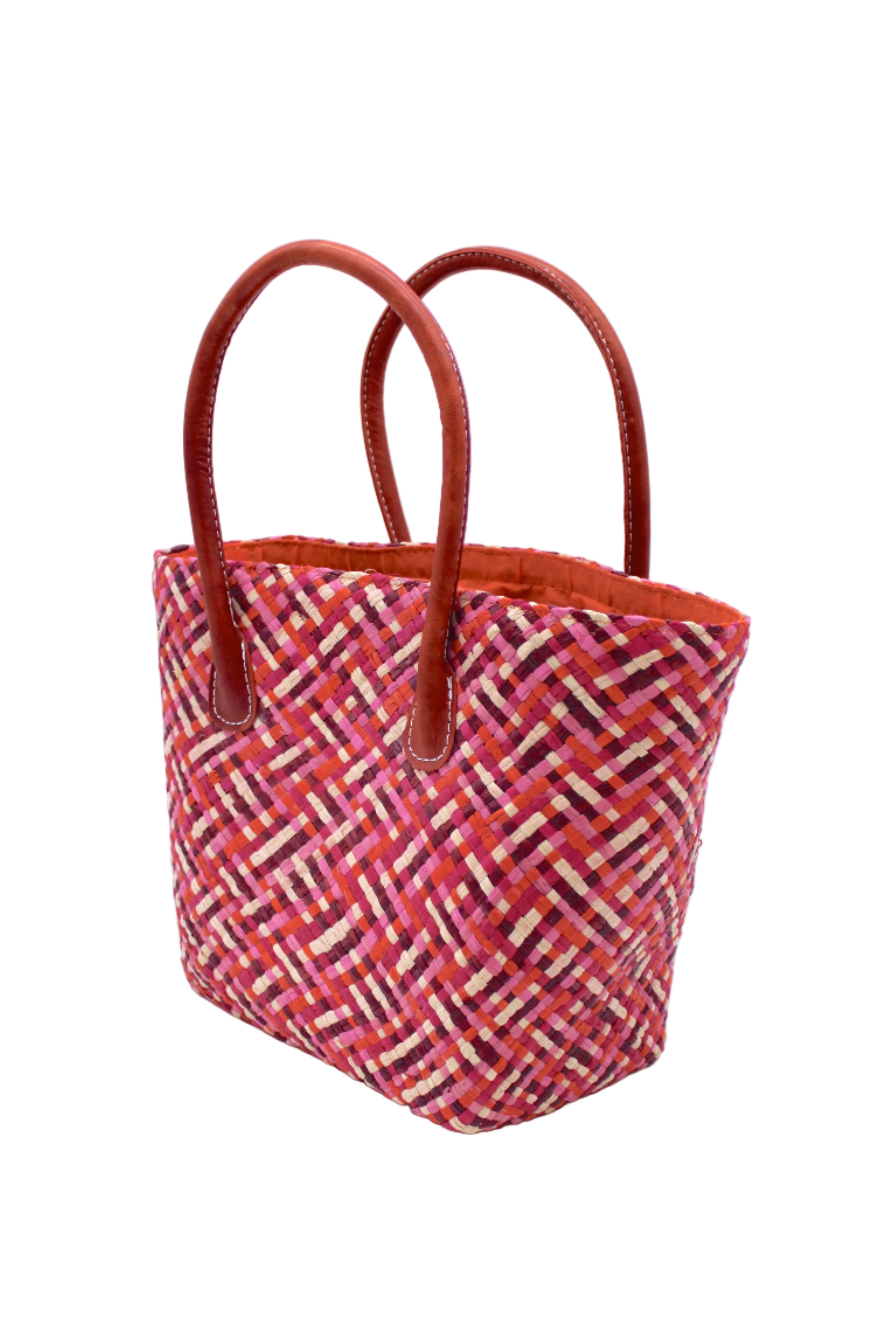 Side view Pianina Passion Multi Small Straw Basket Bag handmade from woven natural raffia palm fiber in a multicolor cross weave pattern of red, light pink, fuchsia, coral, and natural straw color handbag purse with leather handles - Shebobo