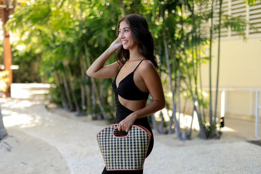 Model wearing Ricky black and natural straw colored loomed raffia gingham pattern bucket shaped handbag with leather finishings purse bag - Shebobo