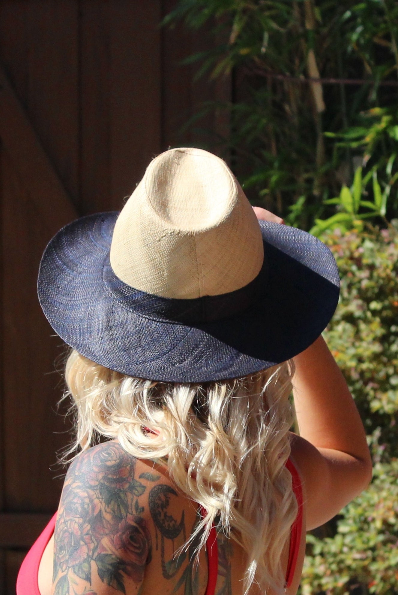 Model wearing Riley 3" Brim Panama Unisex Two Tone Straw Hats handmade loomed raffia palm fiber in a solid hue of natural straw color on the crown and solid black on the brim with matching attached hat band lightweight breathable uv/sun protection straw sun hat - Shebobo