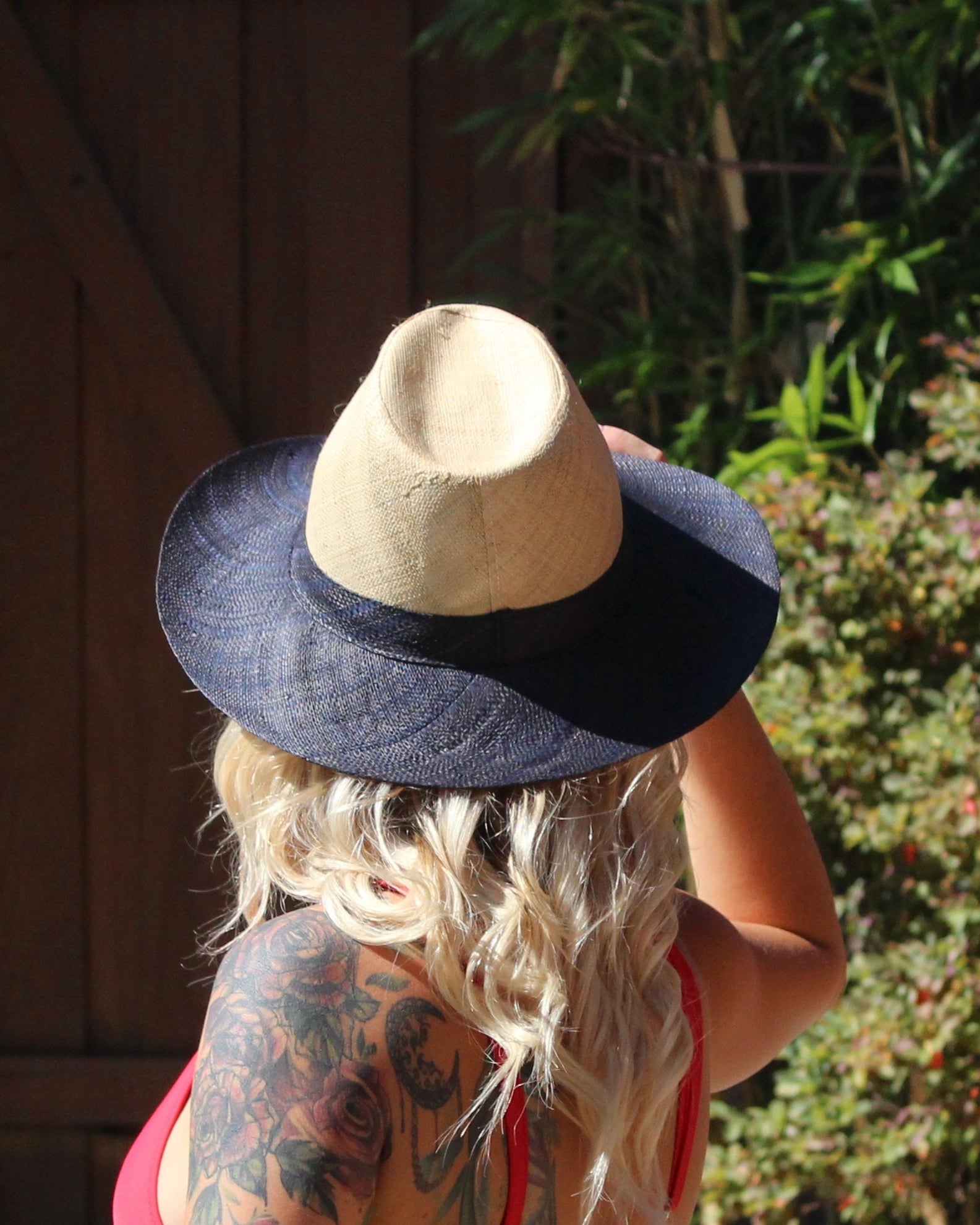 Model wearing Riley 3" Brim Panama Unisex Two Tone Straw Hats handmade loomed raffia palm fiber in a solid hue of natural straw color on the crown and solid black on the brim with matching attached hat band lightweight breathable uv/sun protection straw sun hat - Shebobo