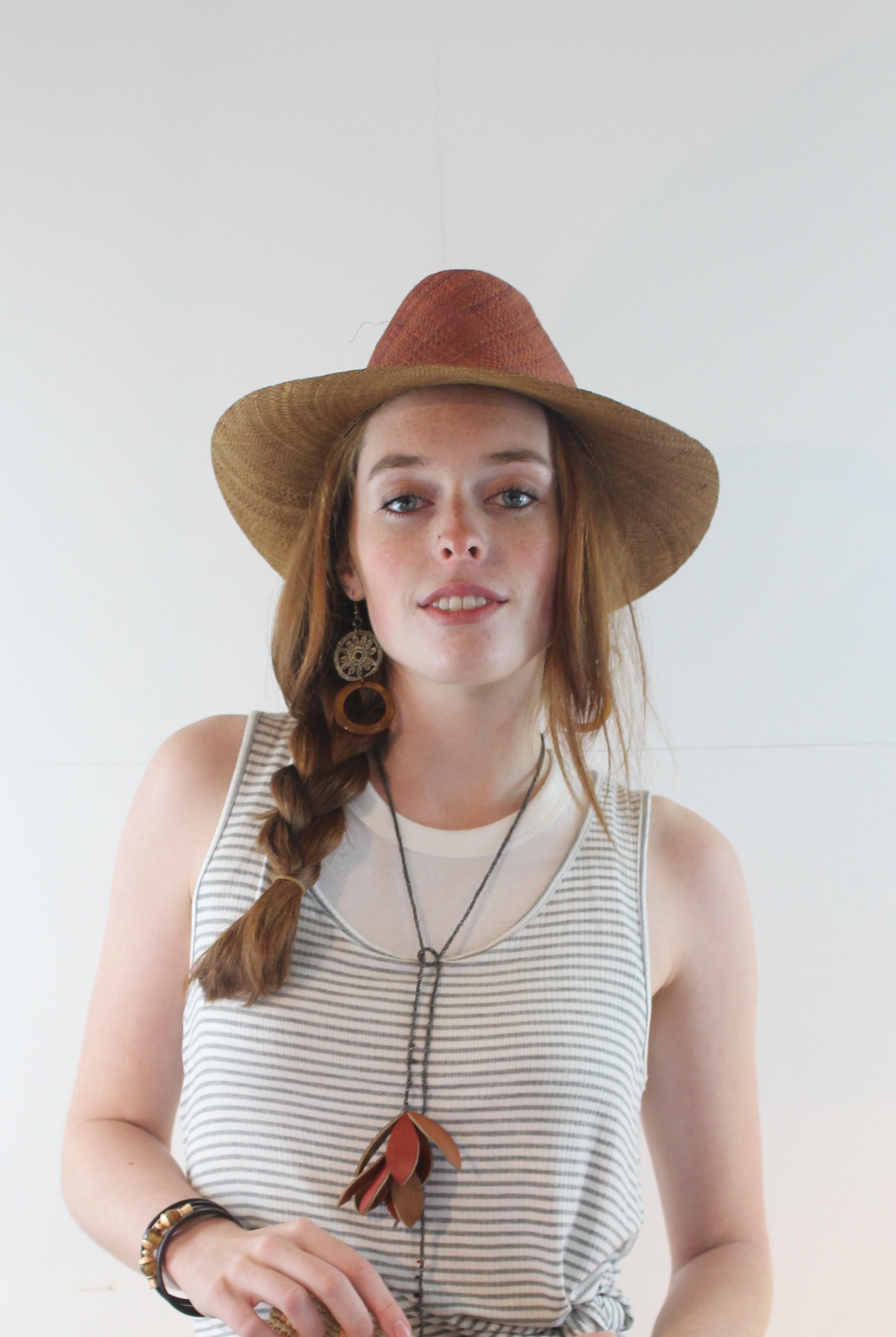 Model wearing Riley 3" Brim Panama Unisex Two Tone Straw Hats handmade loomed raffia palm fiber in a solid hue of cinnamon/tobacco/dark/brown on the crown and solid whisky caramel/red/brown on the brim with matching attached hat band lightweight breathable uv/sun protection straw sun hat - Shebobo