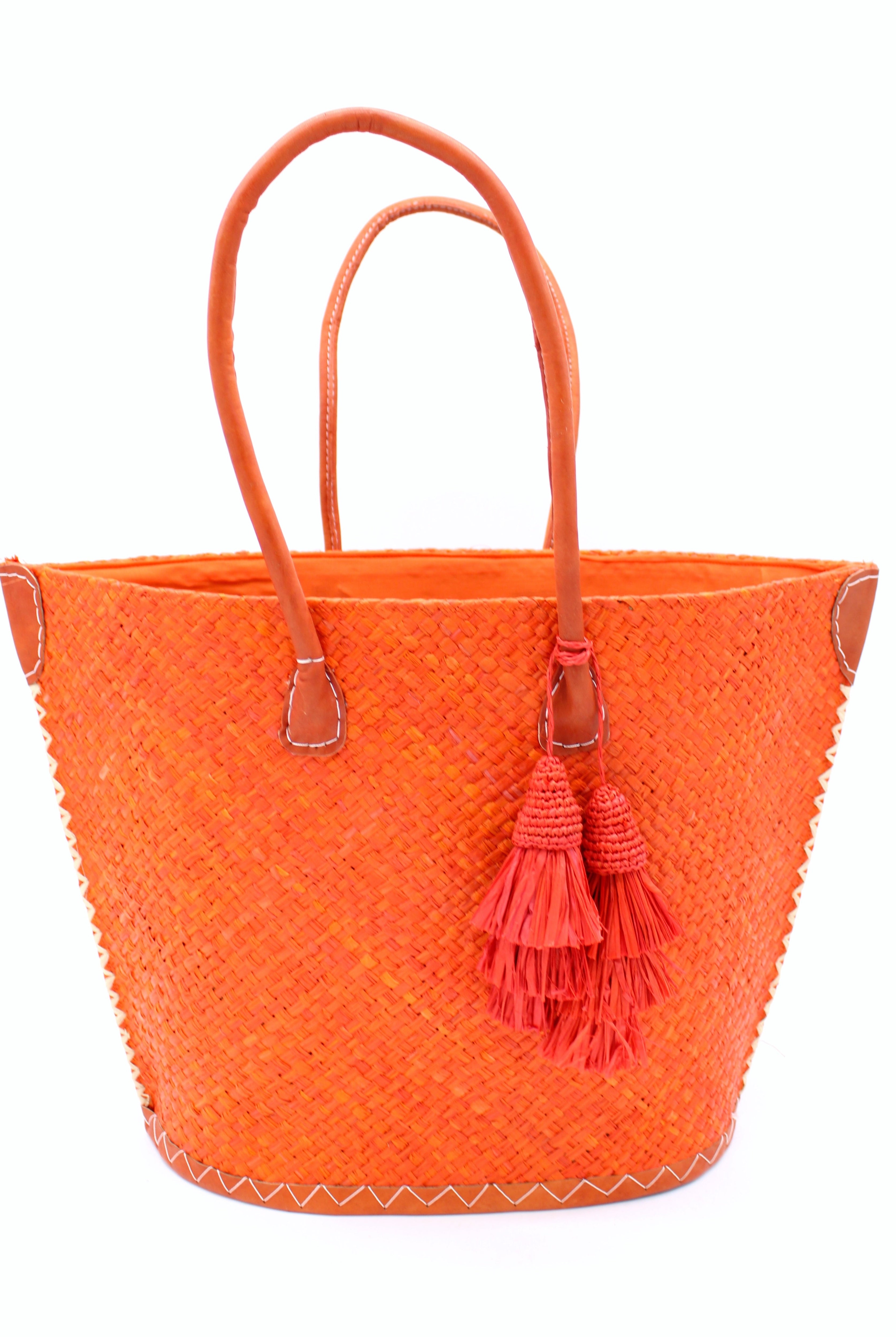 Santa Ynez Woven Small Straw Tote Bag with Tassel Charm Embellishment handmade woven raffia palm fiber in a solid hue of coral orange/red with matching tassel tie charm embellishment and leather handles beach bag - Shebobo