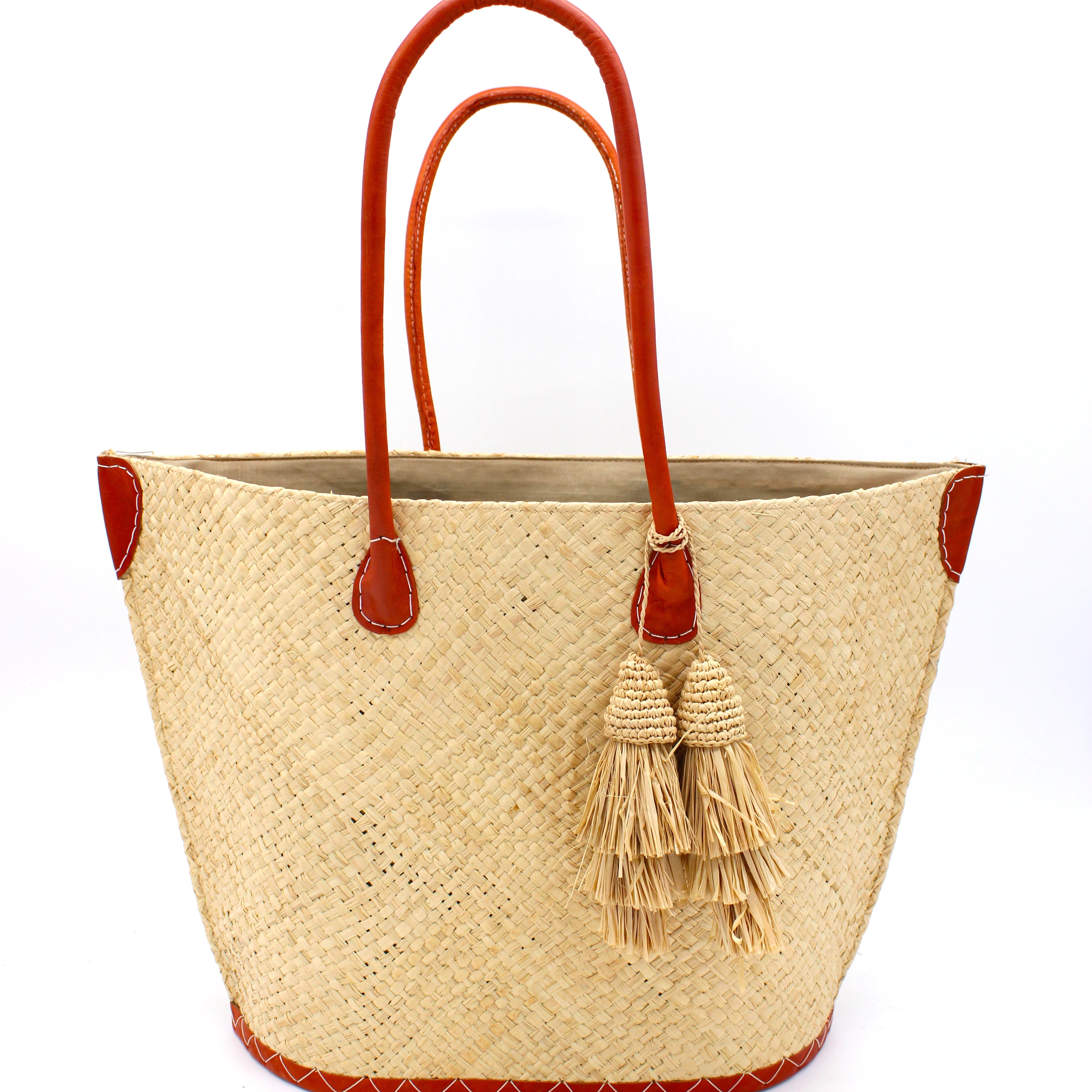 Santa Ynez Woven Small Straw Tote Bag with Tassel Charm Embellishment handmade woven raffia palm fiber in a solid hue of natural straw color with matching tassel tie charm embellishment and leather handles beach bag - Shebobo
