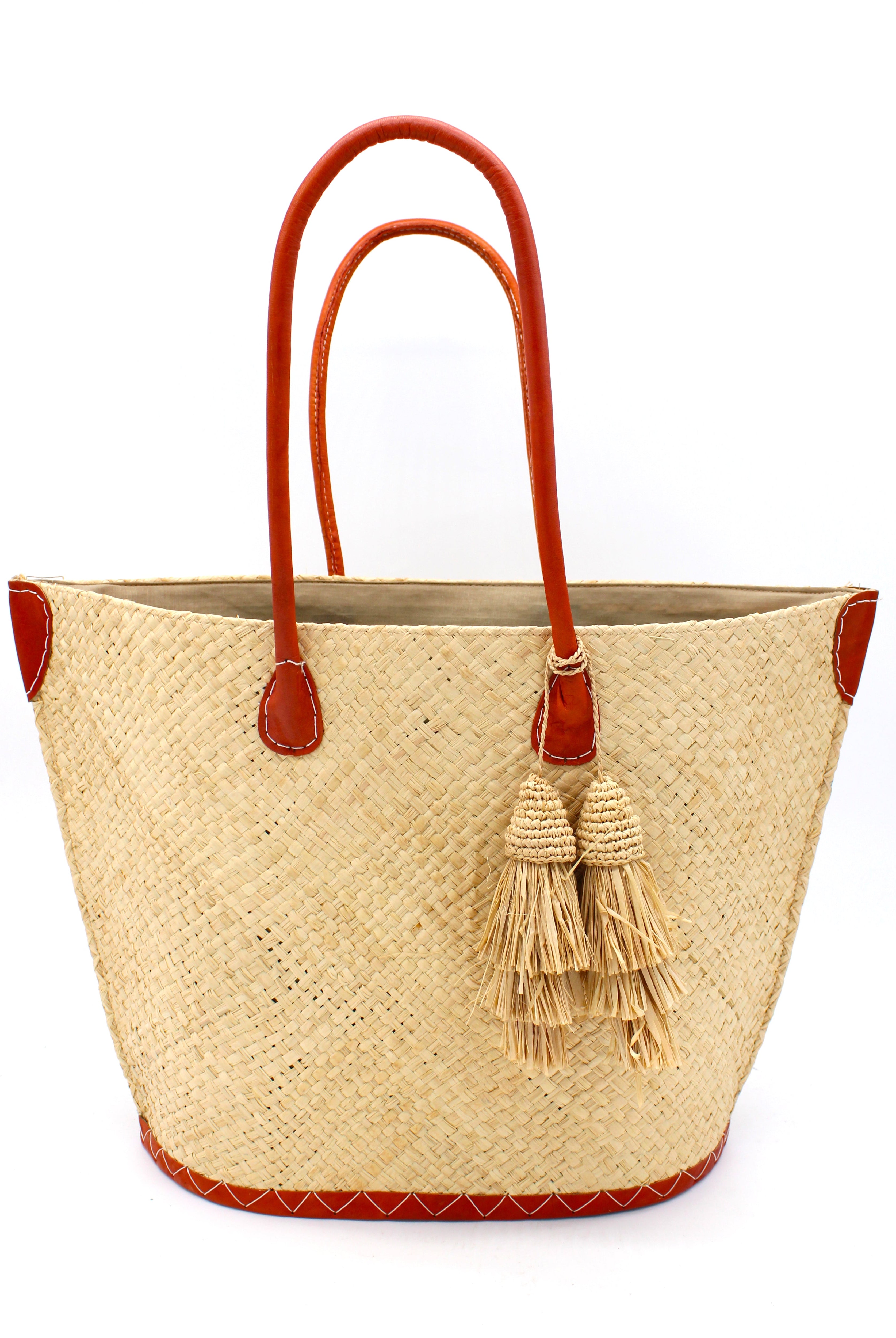 Santa Ynez Woven Small Straw Tote Bag with Tassel Charm Embellishment handmade woven raffia palm fiber in a solid hue of natural straw color with matching tassel tie charm embellishment and leather handles beach bag - Shebobo