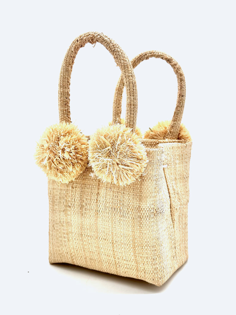 Schooner Natural Straw Mini Bag with Pompom Accent handmade loomed natural raffia palm fiber in natural straw color with four natural raffia pompom embellishments at the base of each handle attachment tiny purse extra small handbag - Shebobo