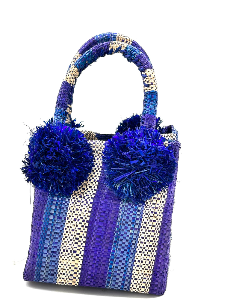 Schooner Blue Wave Multicolor Straw Mini Bag with Pompom Accent handmade loomed natural raffia palm fiber in multicolor tones of navy blue, turquoise blue, and natural straw color vertical stripe pattern with four navy raffia pompom embellishments at the base of each handle attachment tiny purse extra small handbag - Shebobo