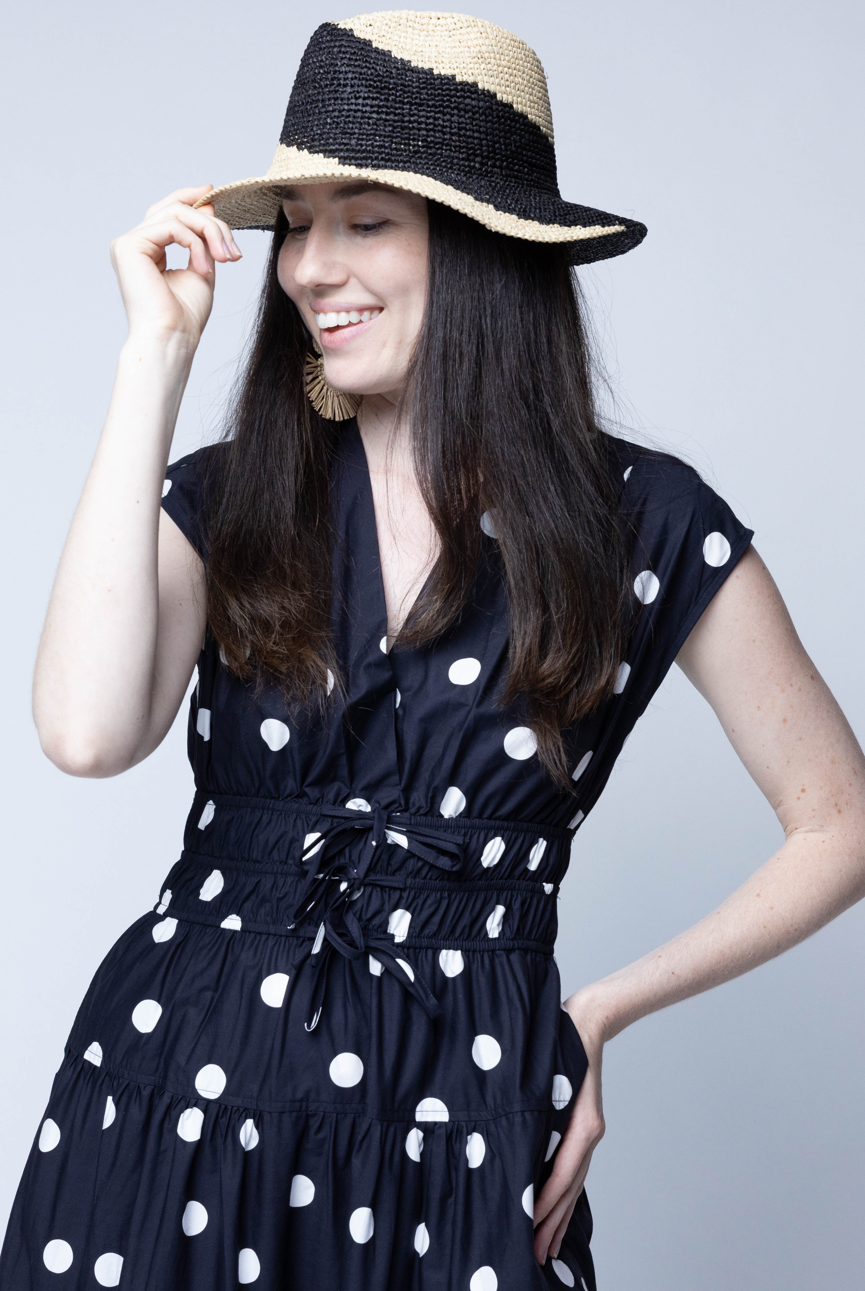 Model wearing Sequoia Black and Natural 3" Brim Swirl Crochet Panama Unisex Straw Hats handmade crochet natural raffia palm fiber in a two tone color swirl design of black and natural straw color spiraling together from wide bands around the brim to a narrow twist at the top of the crown - Shebobo