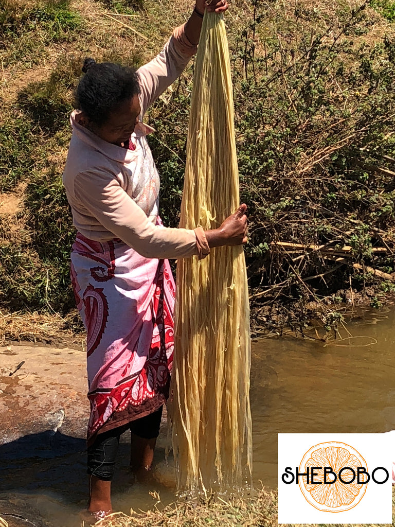 Shebobo Artisan in Madagascar washing raffia palm fibers to be used in handmade loomed or crochet natural resources straw accessories for Shebobo