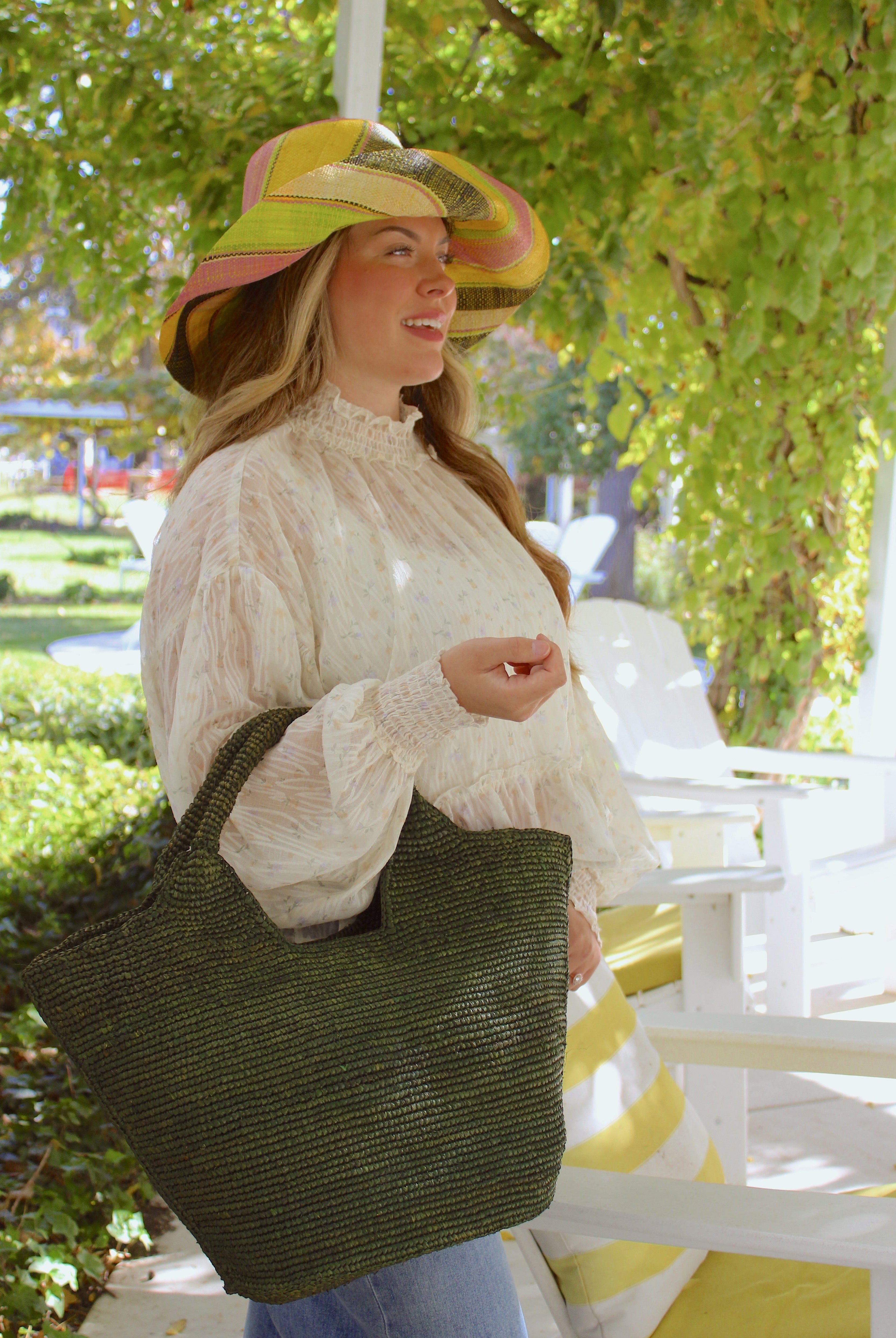 Model wearing St. Tropez Heart Shaped Crochet Straw Basket Handbag handmade crochet natural raffia palm fiber in a solid hue of Deep Green dark/forrest/green with a subtle link texture beach bag shoulder bag - Shebobo (with Monica 5" & 7" Wide Brim Multicolor Stripe Pattern Packable Straw Sun Hats)