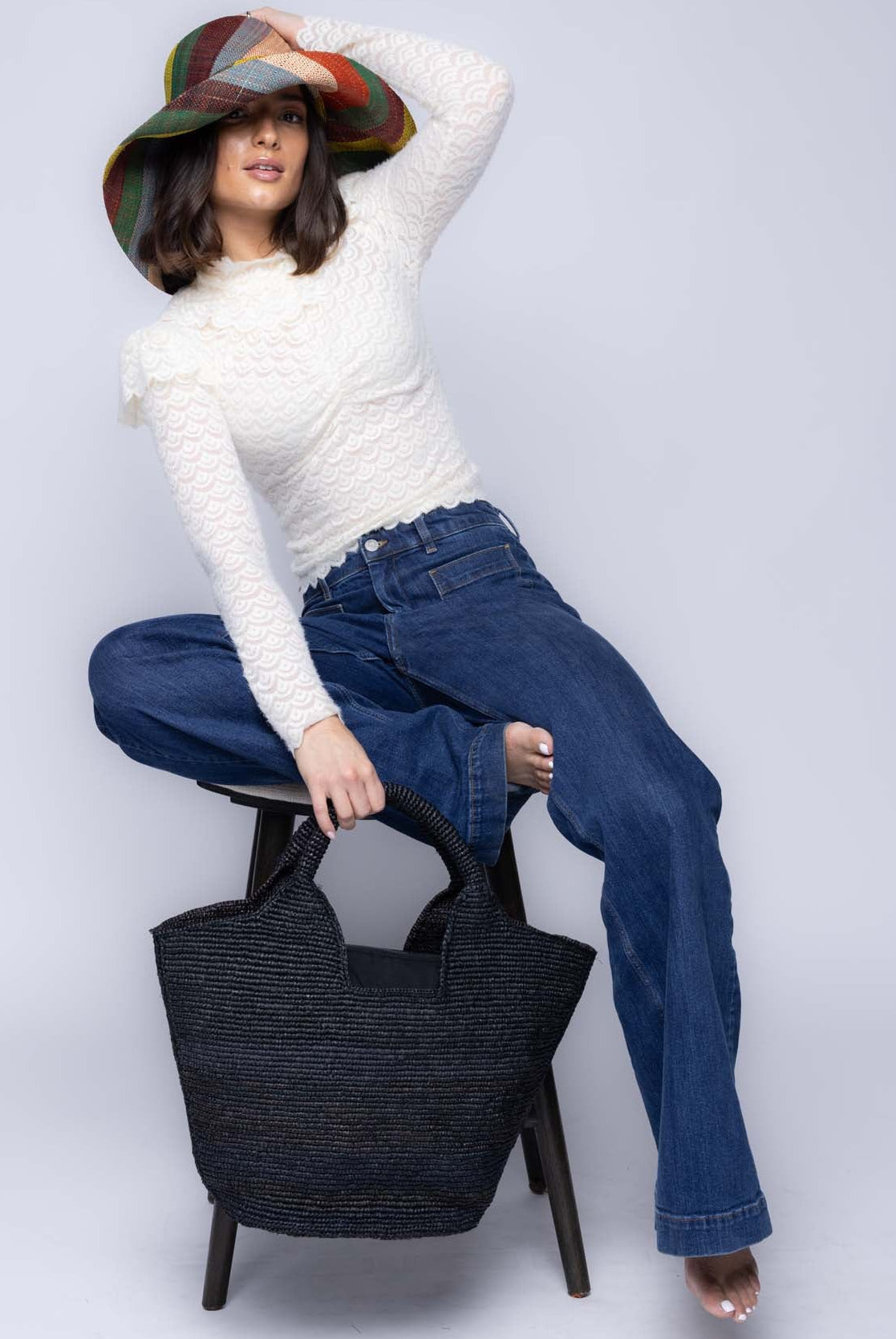 Model wearing St. Tropez Heart Shaped Crochet Straw Basket Handbag handmade crochet natural raffia palm fiber in a solid hue of Black with a subtle link texture beach bag shoulder bag - Shebobo