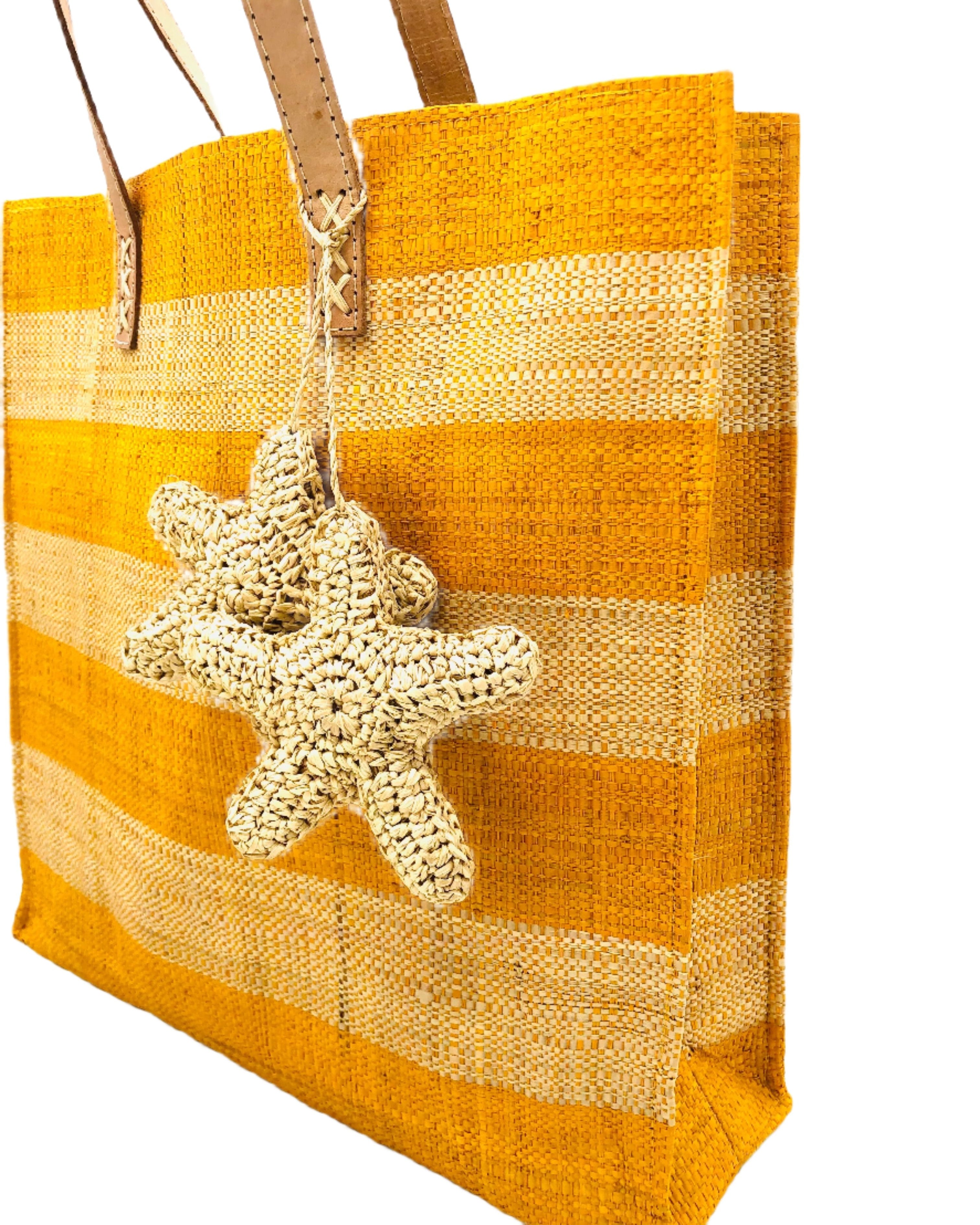 Side view Starfish Straw Bag with Crochet Starfish Charm Embellishment handmade loomed raffia shopping tote in saffron yellow and natural straw color horizontal wide stripe pattern handbag with leather handles - Shebobo