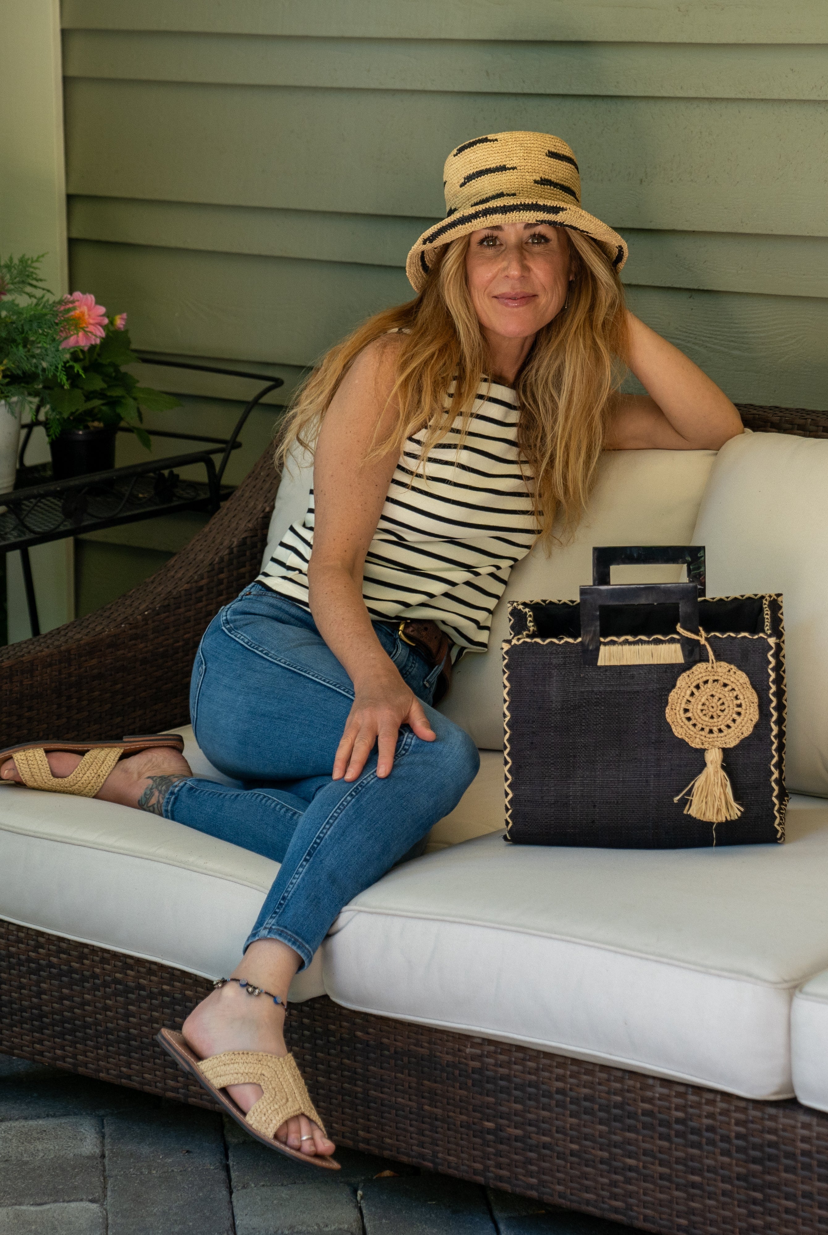Model wearing Stevie Square Black Multicolor Straw Handbag with Horn Handles handmade loomed raffia in black purse with matching liner, contrasting natural cross stitch edging, handle attachment, and crochet doily tassel charm embellishment - Shebobo