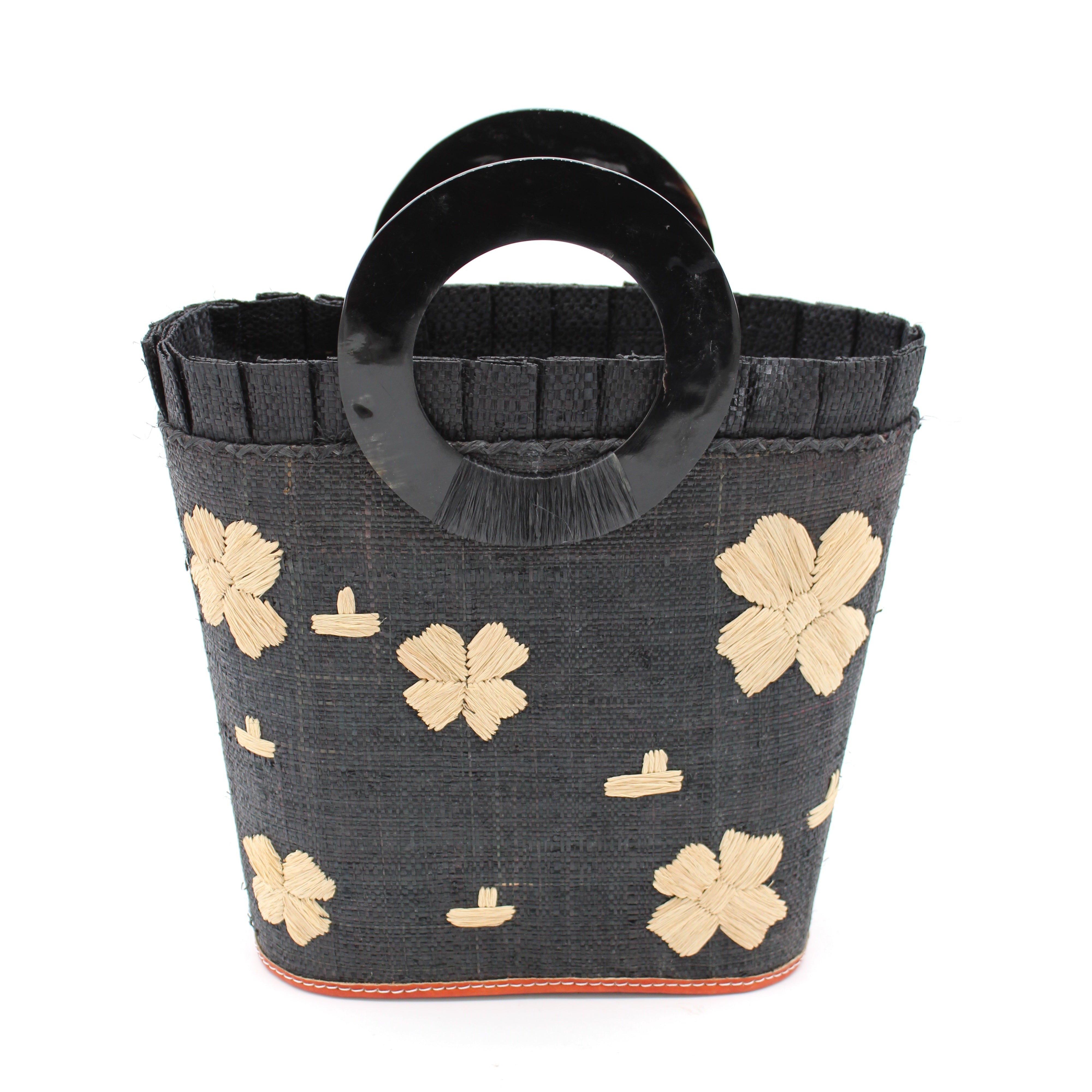 Tulum Straw Bucket Bag with Flower Embroidery and Horn Handle Black Purse with Ruffle Edge handmade loomed raffia palm fiber in a solid hue of black with natural straw color hand embroidered floral pattern with multiple sized flowers and raffia ruffle on the opening handbag - Shebobo