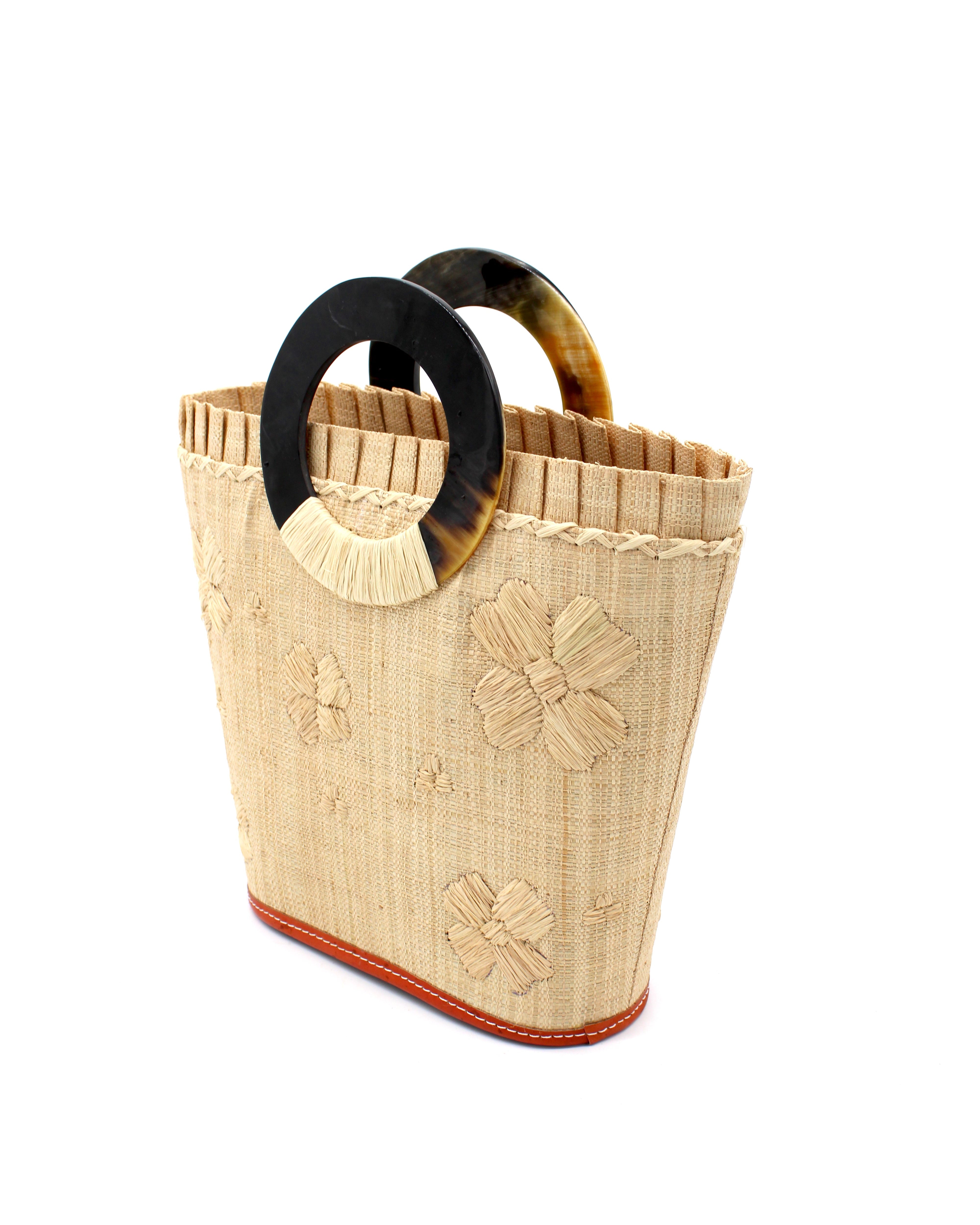 Side View Tulum Straw Bucket Bag with Flower Embroidery and Horn Handle Natural Purse with Ruffle Edge handmade loomed raffia palm fiber in a solid hue of natural straw color with matching subtle hand embroidered floral pattern with multiple sized flowers and raffia ruffle on the opening handbag - Shebobo