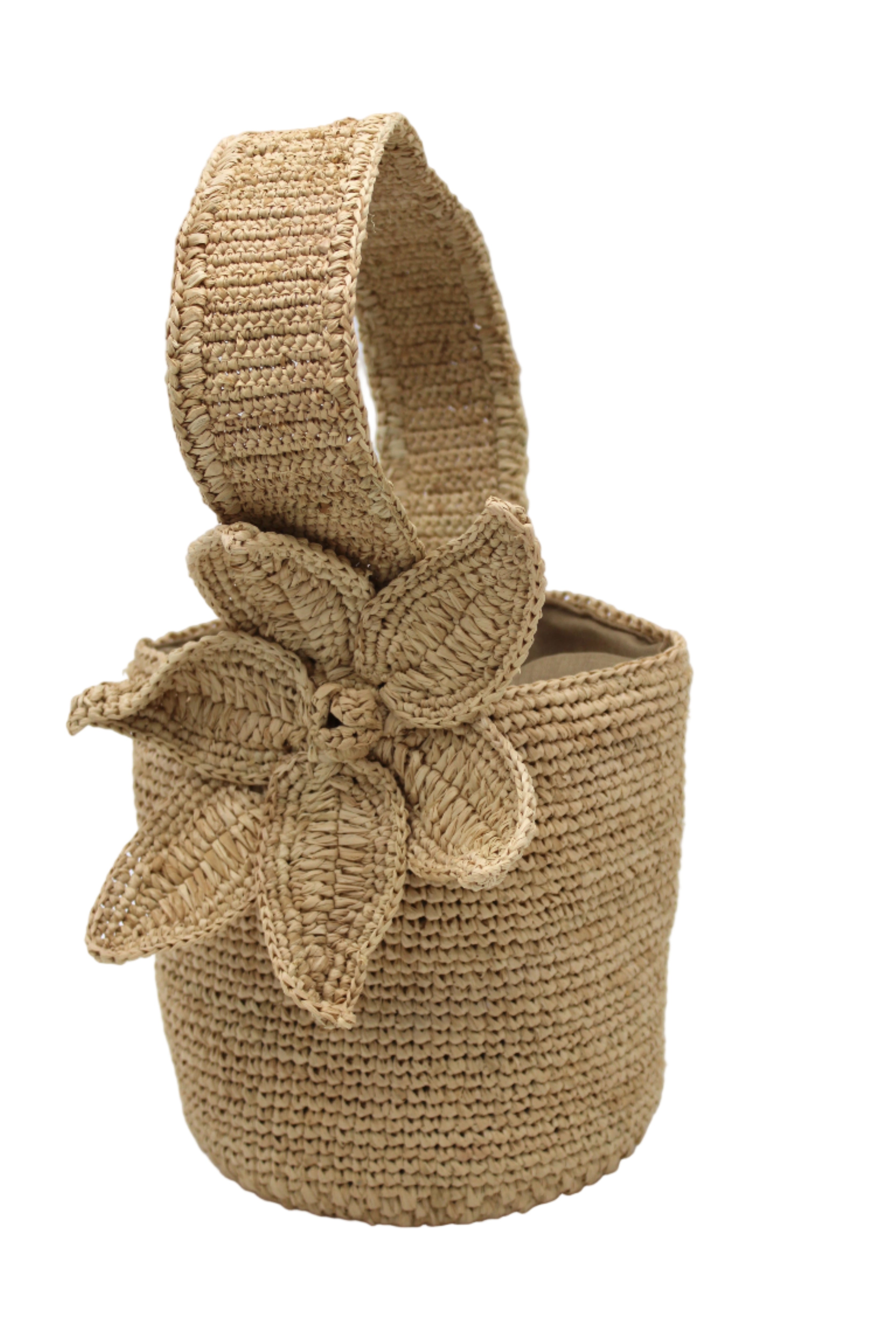 Side view Valencia Mini Crochet Petit Straw Basket Handbag with Flower Embellishment handmade natural raffia palm fiber in a solid hue of Natural straw color crochet in bands of horizontal link pattern texture with integrated strap handle and large flower embellishment - Shebobo