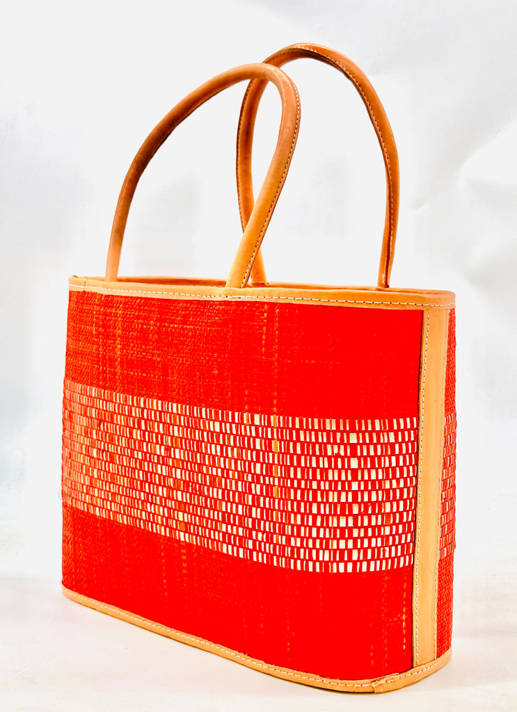 Wynwood Coral Straw Basket Bag Handbag with Metallic Detailing handmade loomed raffia in coral orange/red and silver metallic vegan leather in three evenly sized horizontal bands of color with the metallic weave centered on the purse with leather binding and handles - Shebobo