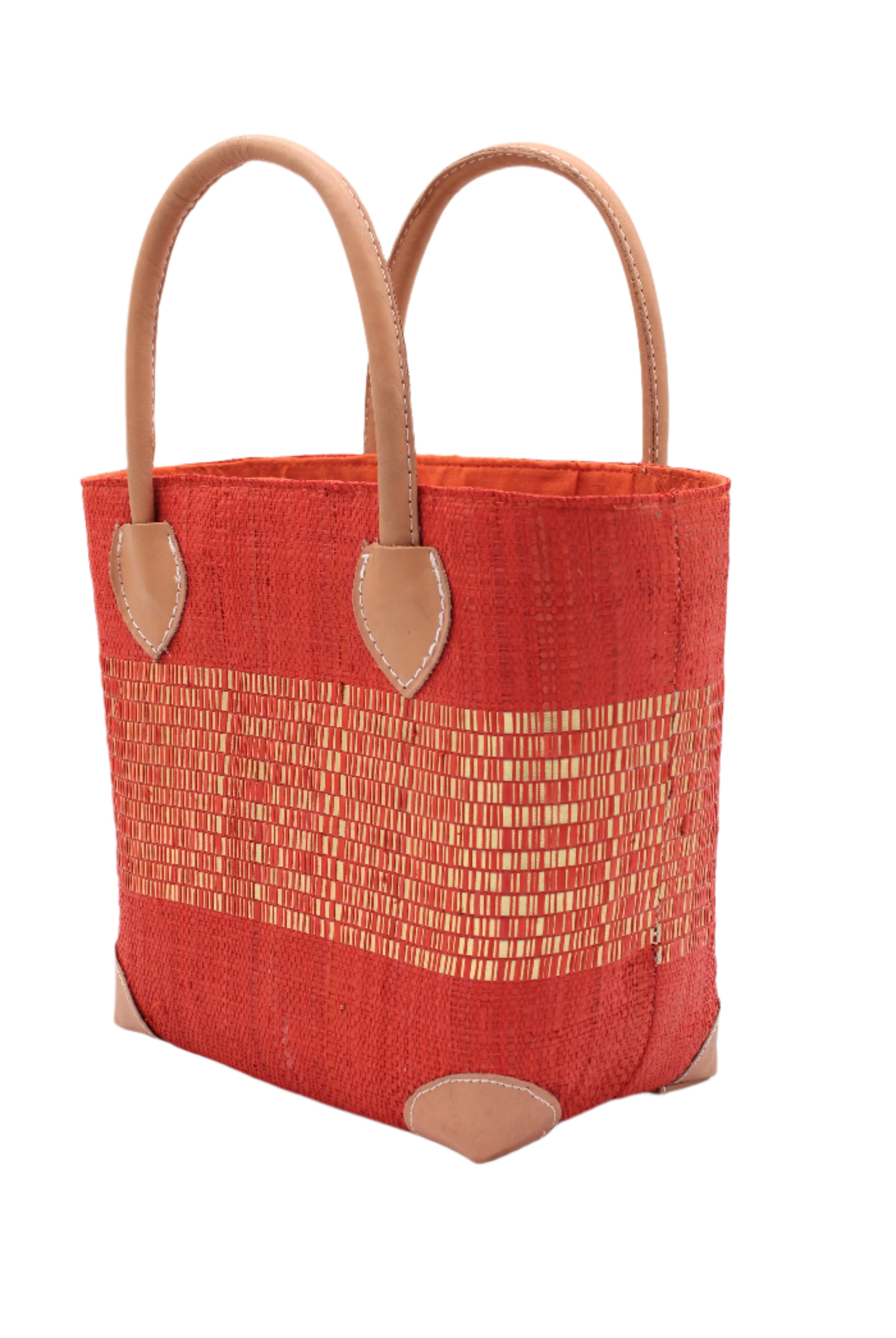 Side View Wynwood Coral Straw Basket Bag with Metallic Detailing Handmade loomed raffia palm fiber in a solid hue of coral orange/red with a wide horizontal band of metallic strands woven in seamlessly handbag purse with leather handles - Shebobo