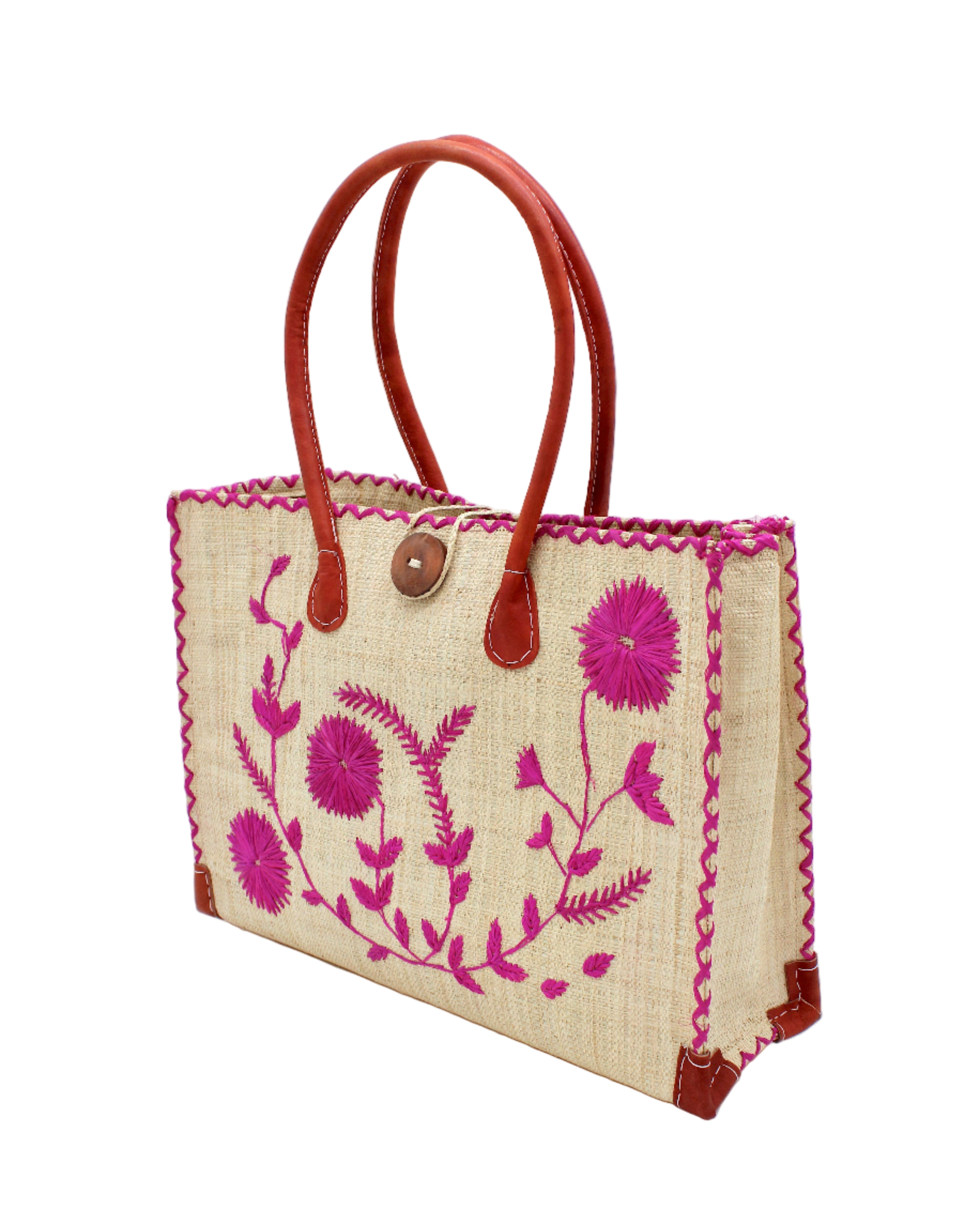 Side view Zafran Natural & Fuchsia Embroidered Straw Beach Bag with Floral Pattern handmade natural raffia palm fiber in a solid hue of natural straw color with asymmetrical floral leaf, vine, and flower pattern in fuchsia hot/bright/barbie/pink with matching cross-stitch edging, leather handles, and wooden button closure shoulder bag handbag tote - Shebobo