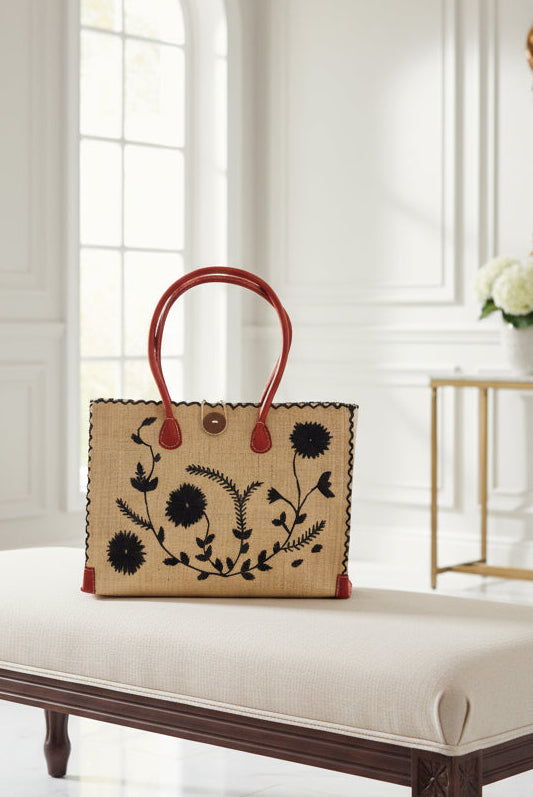 Zafran Natural & Black Embroidered Straw Beach Bag with Floral Pattern handmade natural raffia palm fiber in a solid hue of natural straw color with asymmetrical floral leaf, vine, and flower pattern in black with matching cross-stitch edging, leather handles, and wooden button closure shoulder bag handbag tote - Shebobo