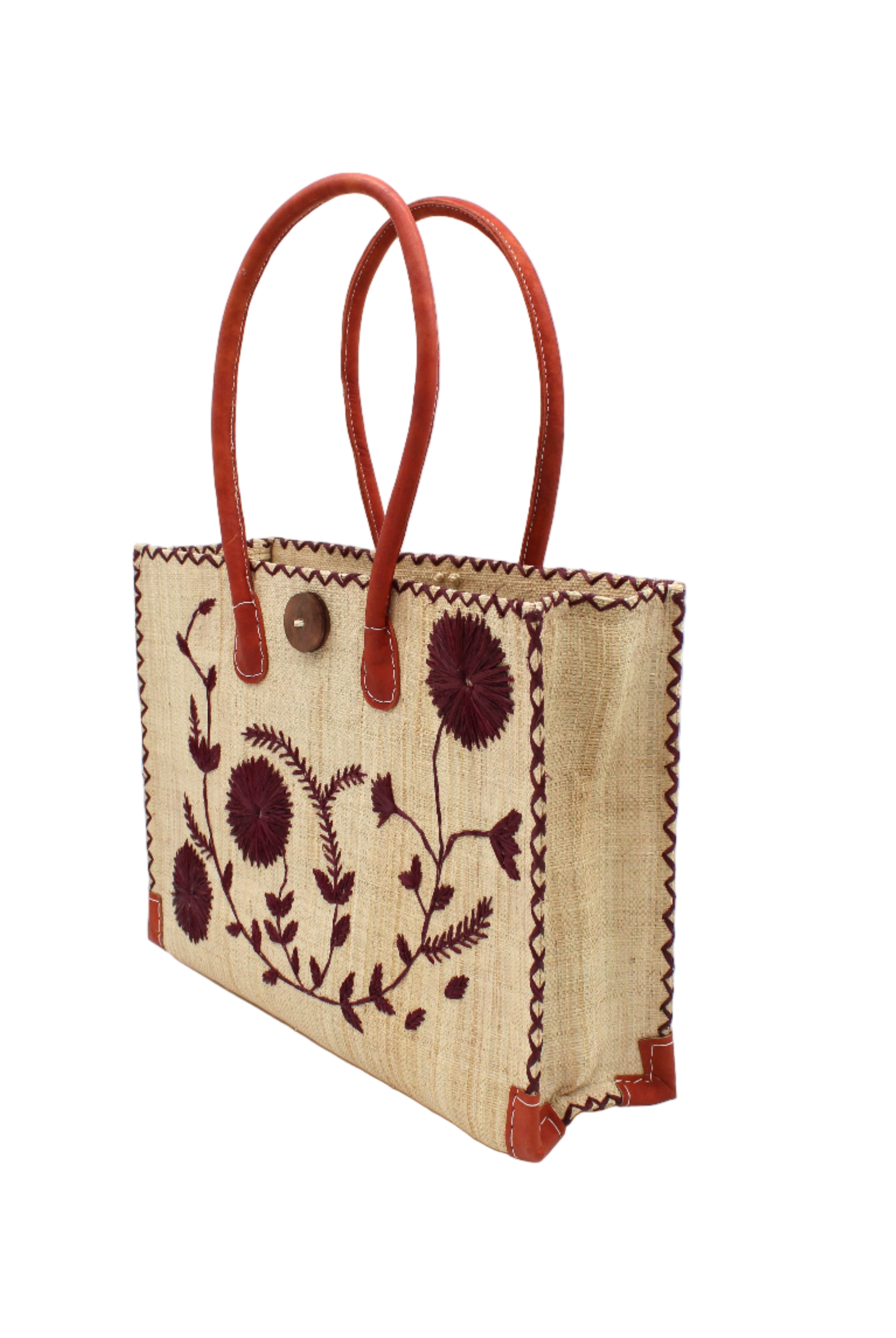 Side view Zafran Natural & Black Embroidered Straw Beach Bag with Floral Pattern handmade natural raffia palm fiber in a solid hue of natural straw color with asymmetrical floral leaf, vine, and flower pattern in umberwine burgundy/bordeaux/claret/dark/red/purple with matching cross-stitch edging, leather handles, and wooden button closure shoulder bag handbag tote - Shebobo