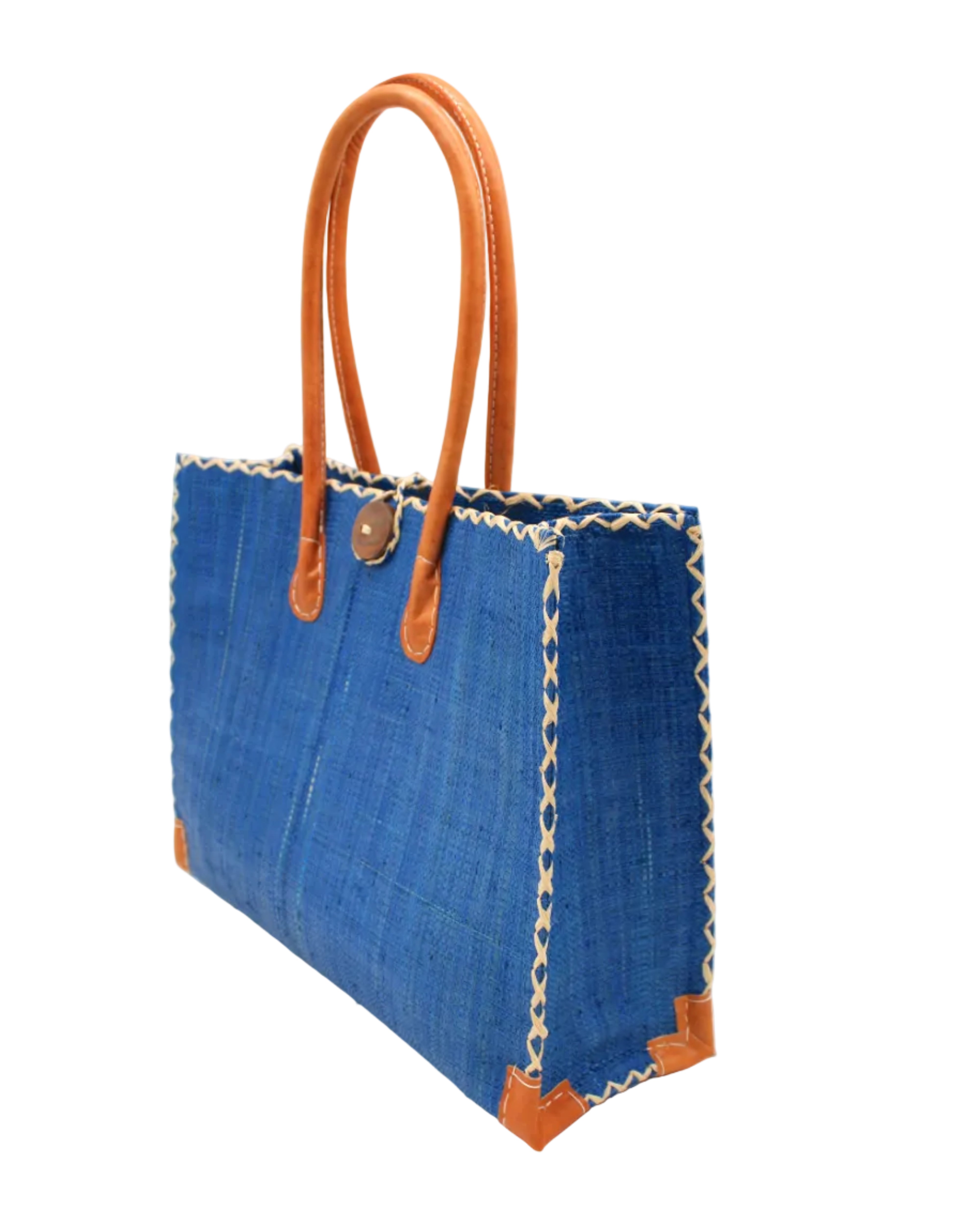 Side view Zafran Straw Beach Bag with Plastic Liner handmade loomed raffia in a solid hue of Azure intense/bright/blue with contrasting natural straw color cross stitch edge binding, wood button closure, and leather handles & feet plus assorted print plastic lining - Shebobo