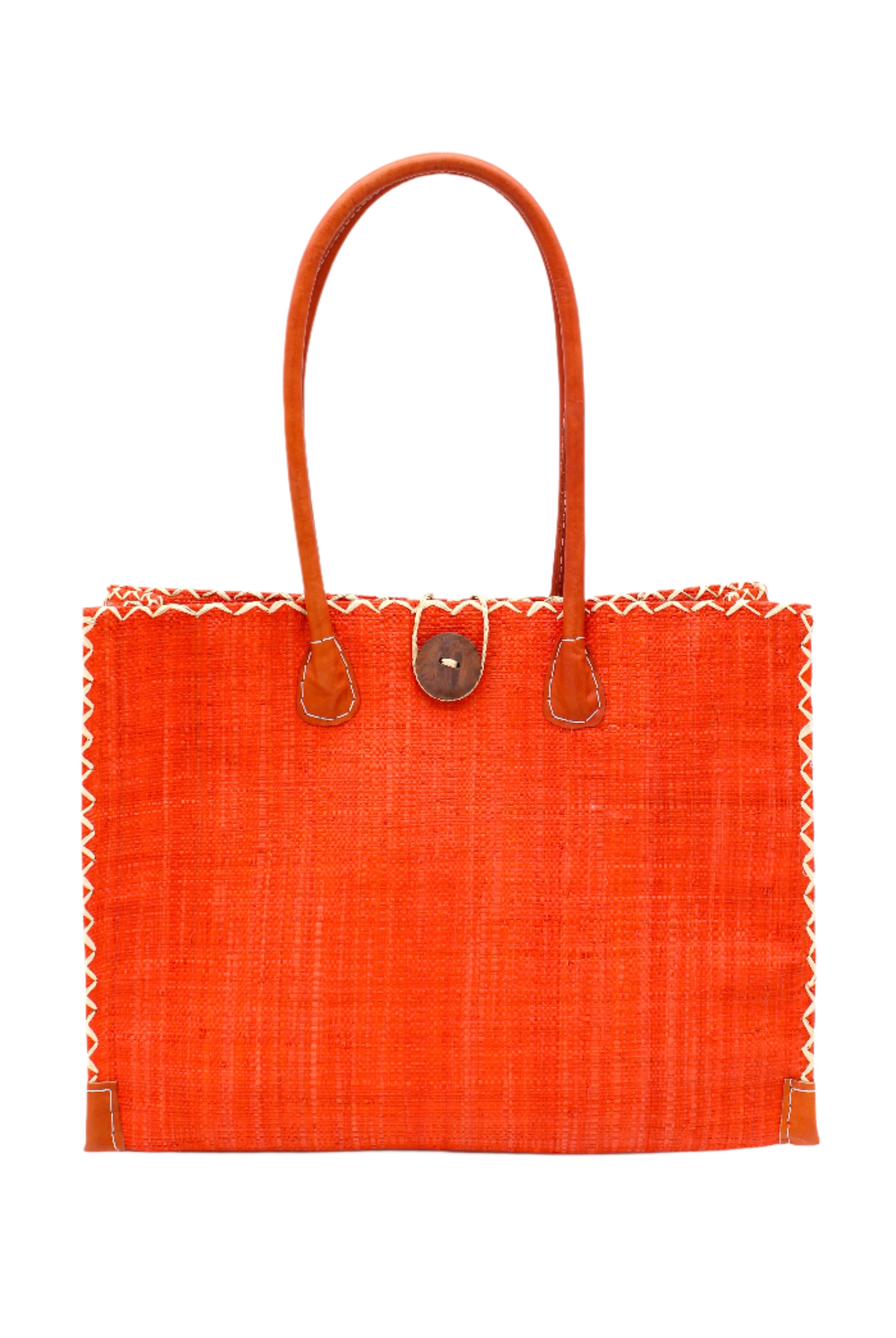 Zafran Straw Beach Bag with Plastic Liner handmade loomed raffia in a solid hue of Coral orange/red with contrasting natural straw color cross stitch edge binding, wood button closure, and leather handles & feet plus assorted print plastic lining - Shebobo