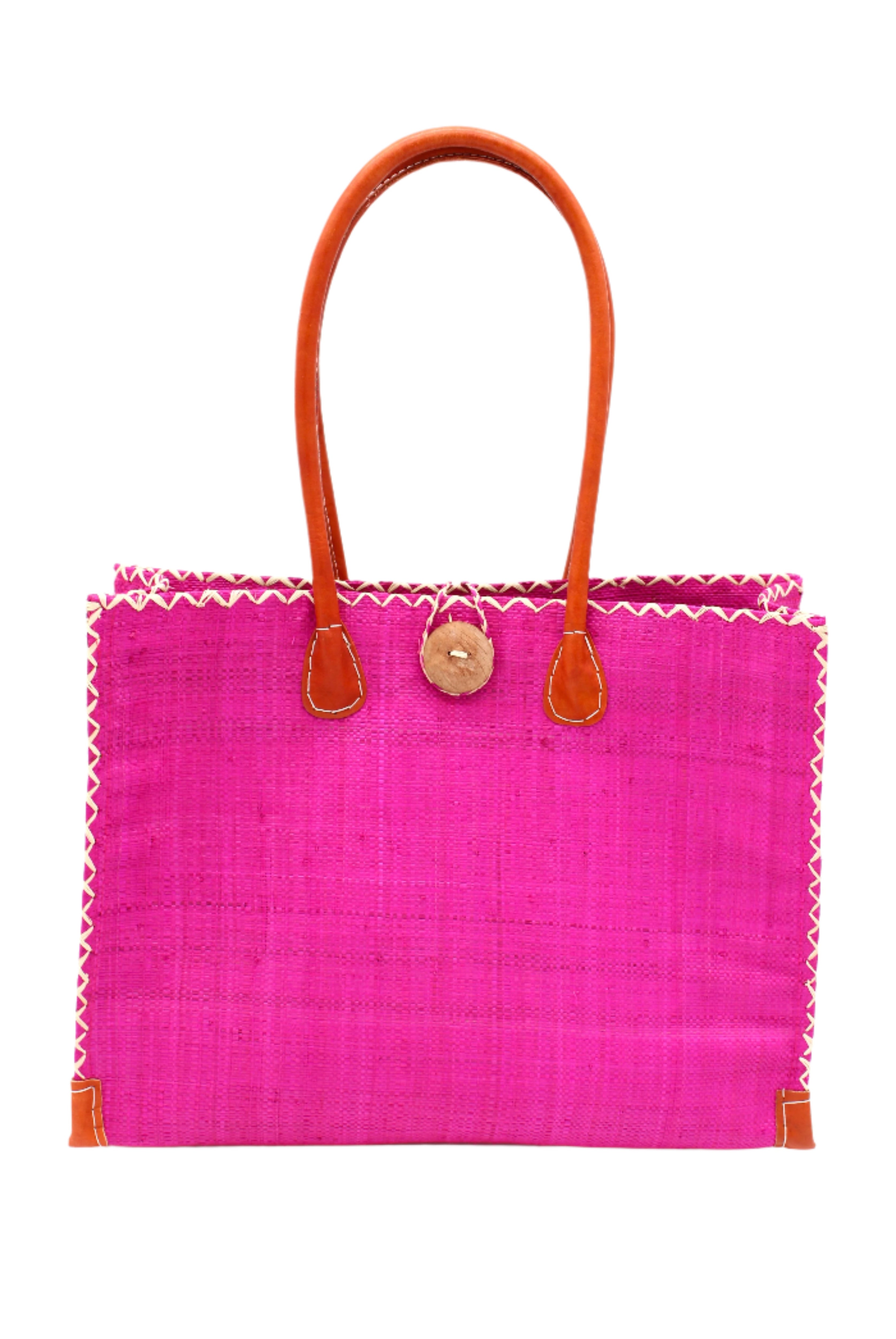 Zafran Straw Beach Bag with Plastic Liner handmade loomed raffia in a solid hue of Fuchsia hot/bright/barbie/pink with contrasting natural straw color cross stitch edge binding, wood button closure, and leather handles & feet plus assorted print plastic lining - Shebobo