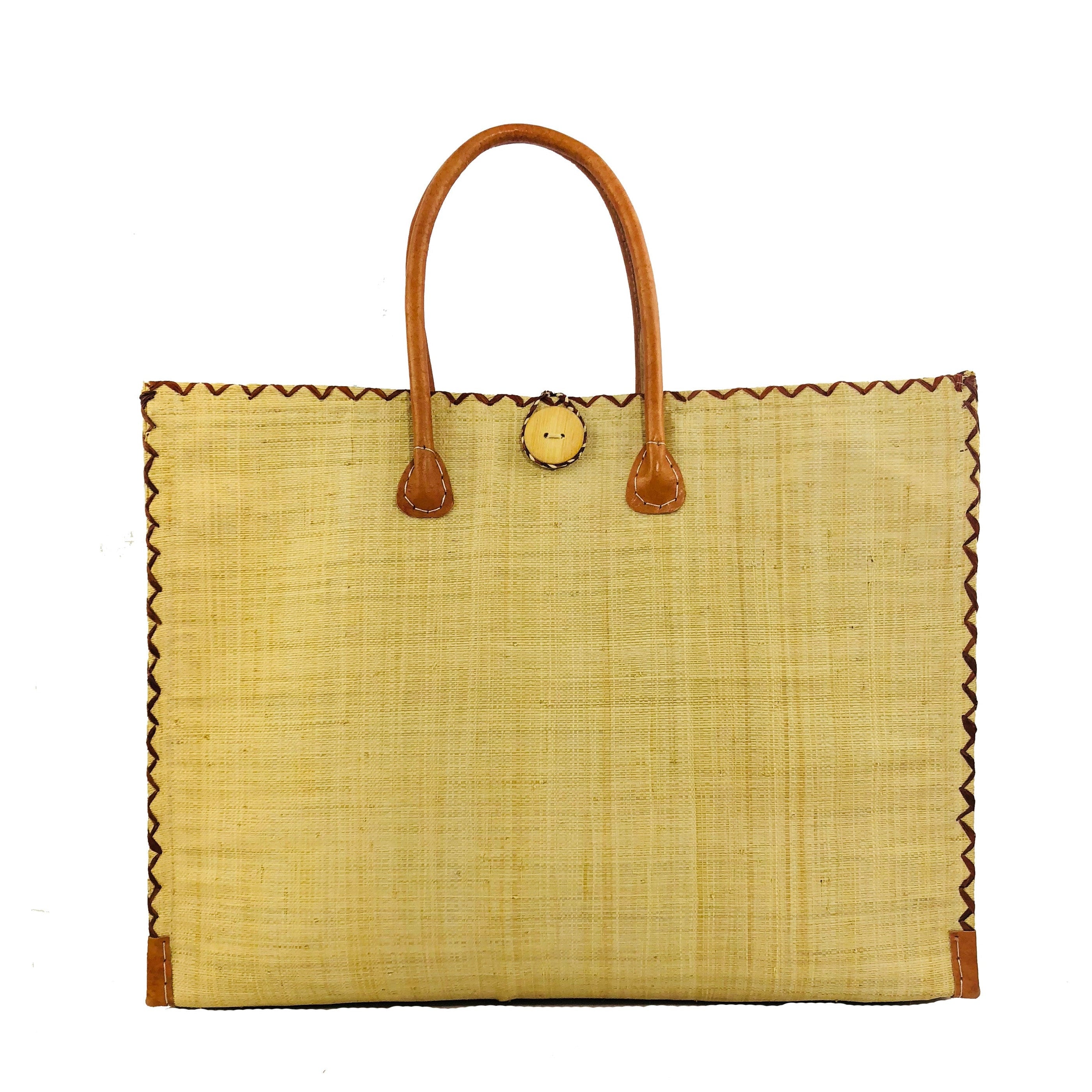 Zafran Straw Beach Bag with Plastic Liner handmade loomed raffia in natural straw color with contrasting cross stitch edge binding, wood button closure, and leather handles & feet plus assorted print plastic lining - Shebobo